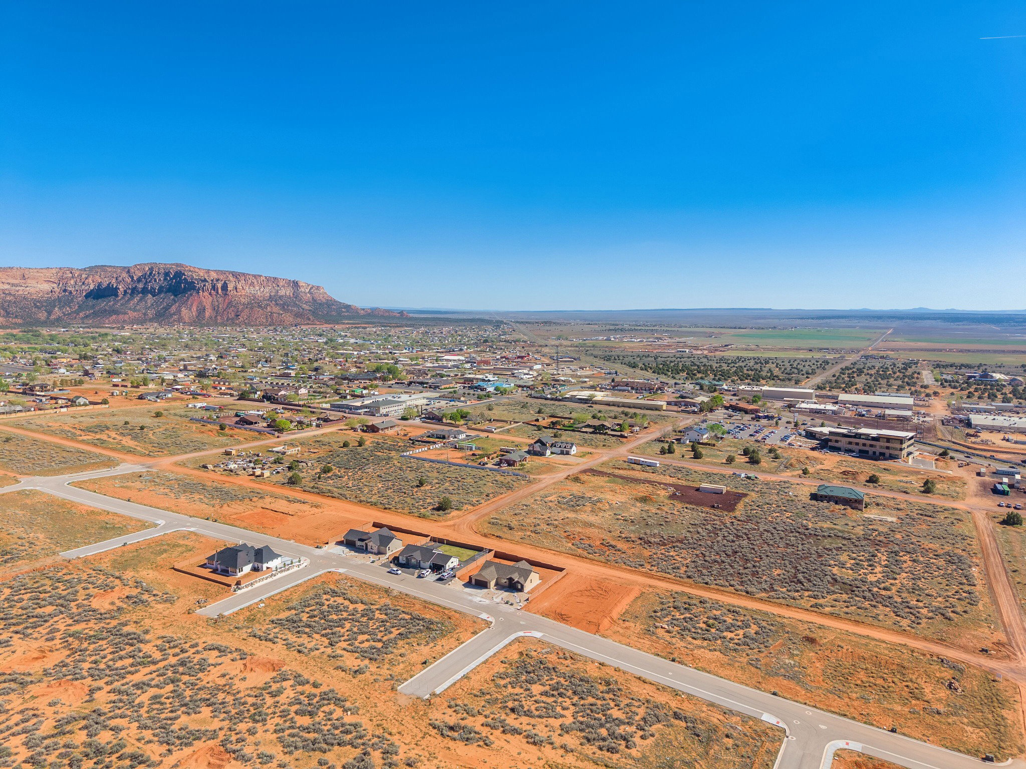 Expansive desert landscape with established residential areas and undeveloped plots