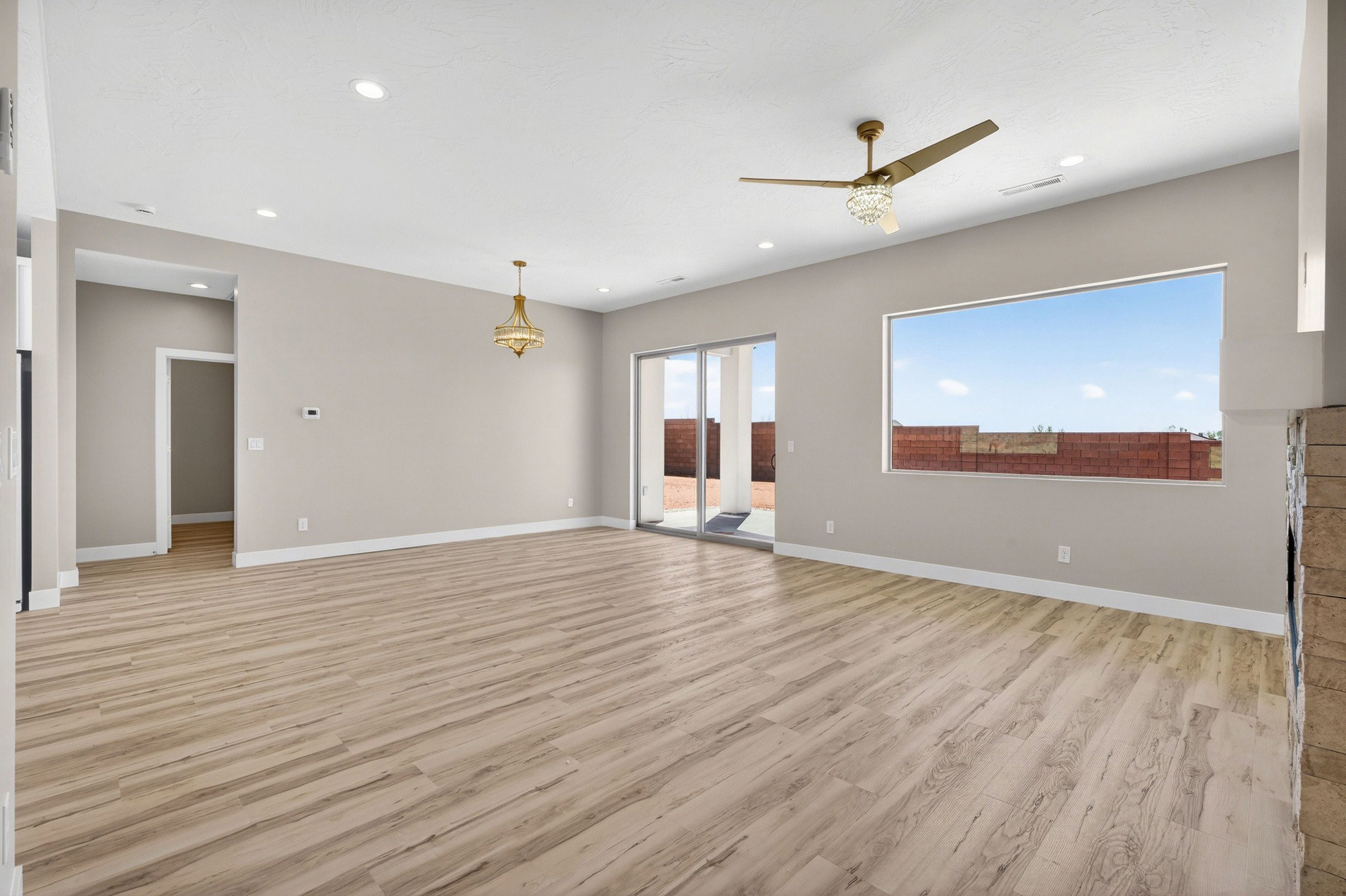 Expansive living area featuring wood-finish flooring, recessed lighting, and a contemporary ceiling fan