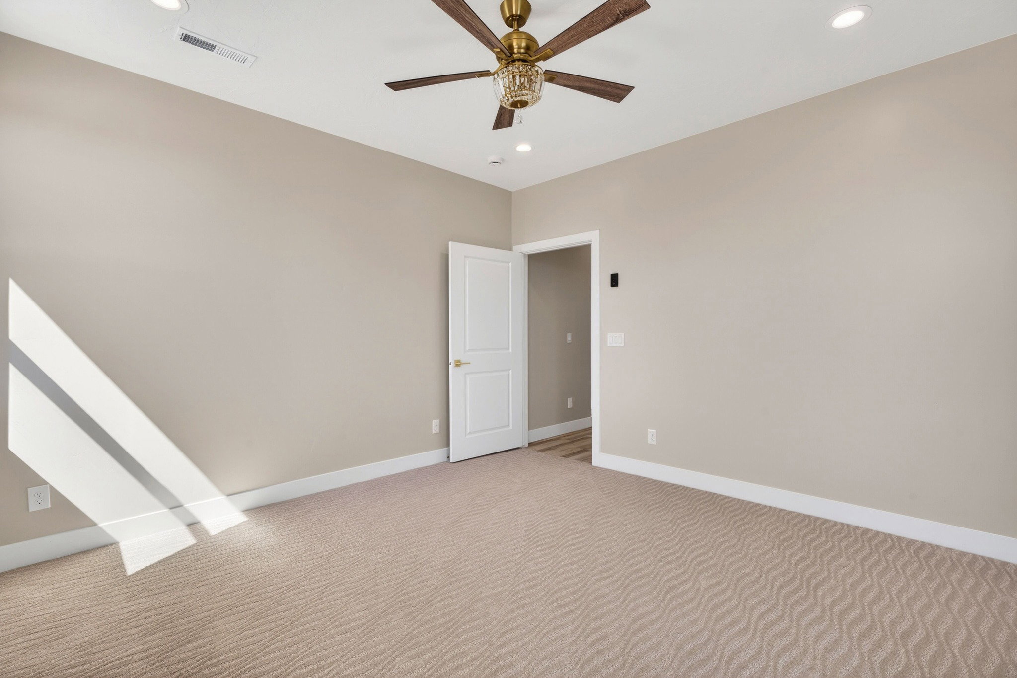 Neutral-toned walls and plush patterned carpeting define this interior space