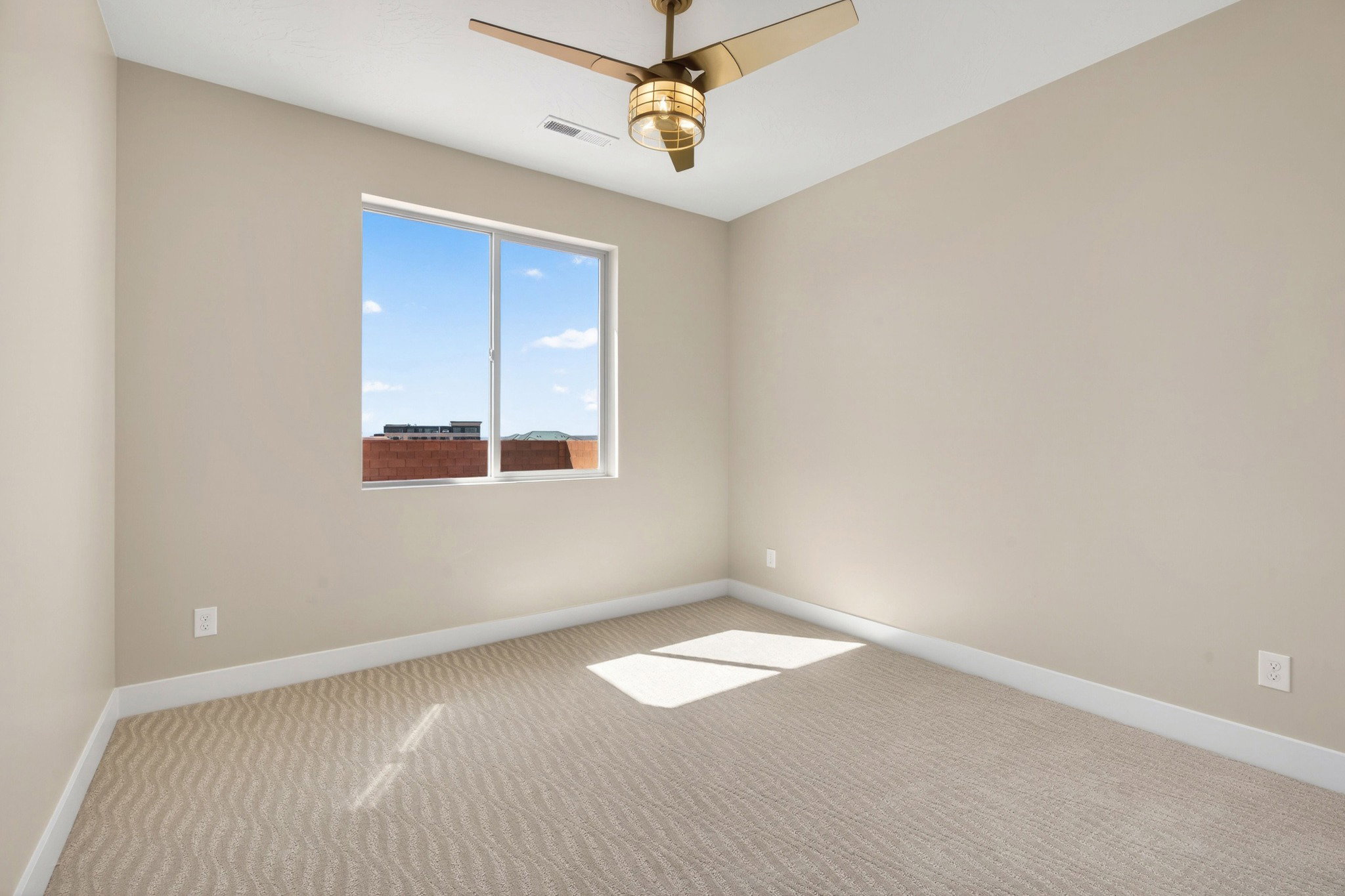 Room featuring a large window, neutral wall color, and patterned carpeting