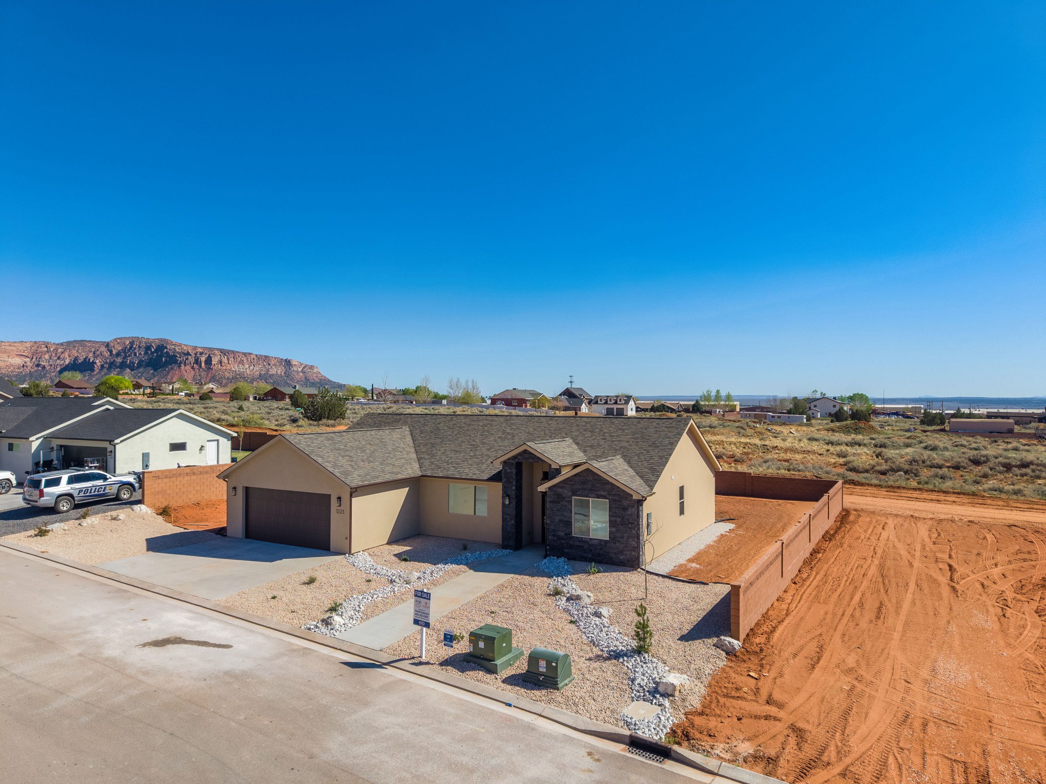 Single-story residence featuring a two-car garage, stone and stucco exterior, and a gravel and rock front yard