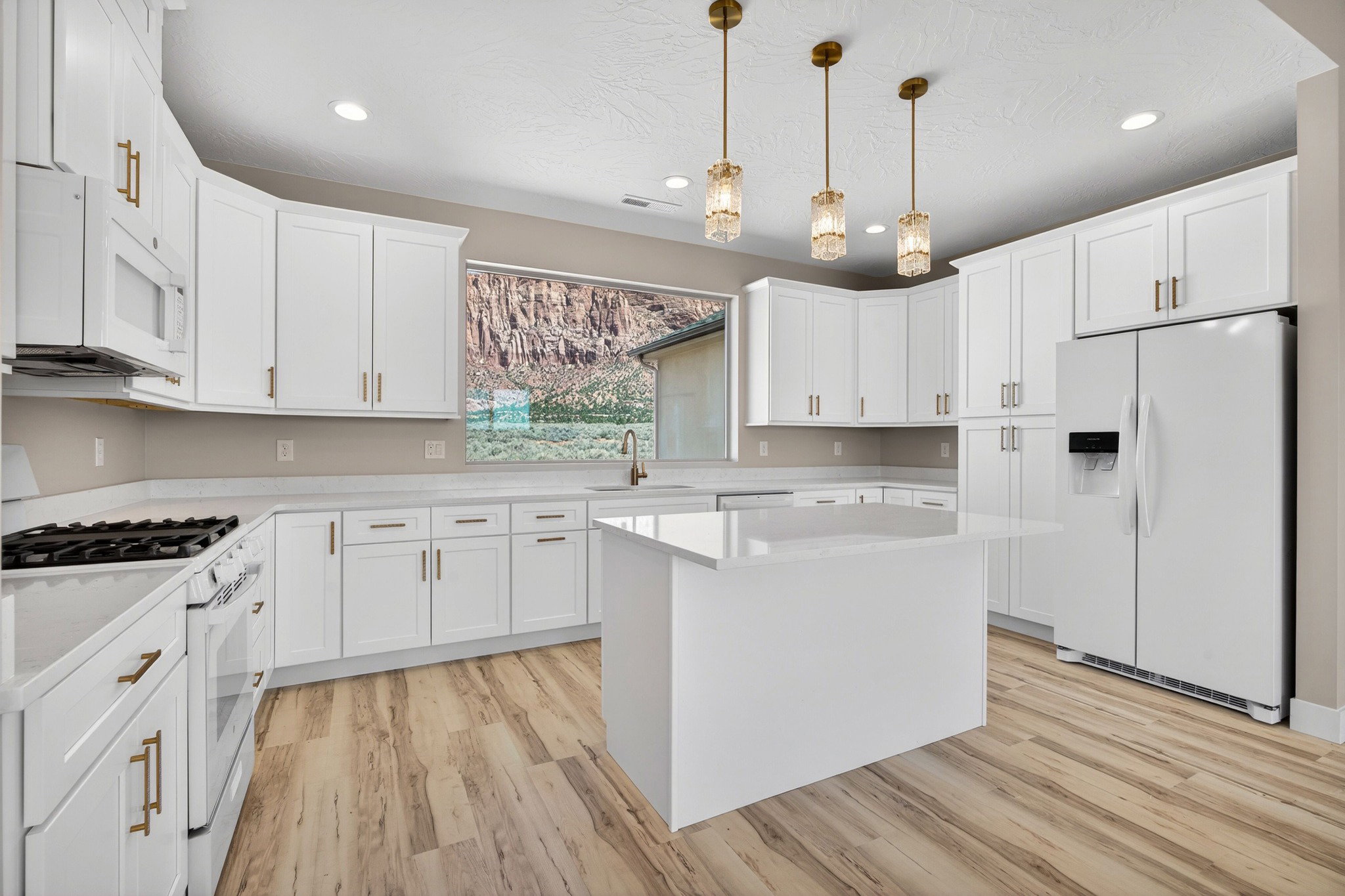 Spacious kitchen featuring white cabinetry, light-toned countertops, and wood-finish flooring