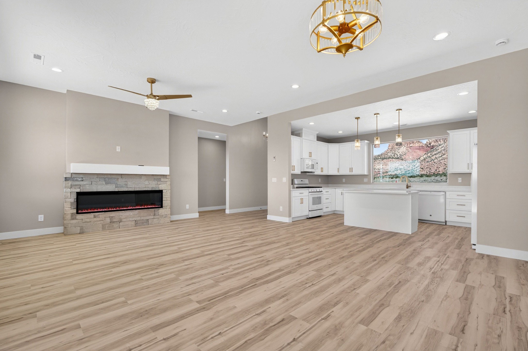 Open-concept living area featuring wood-finish flooring, a stone-clad fireplace with a built-in electric insert, and a modern ceiling fan