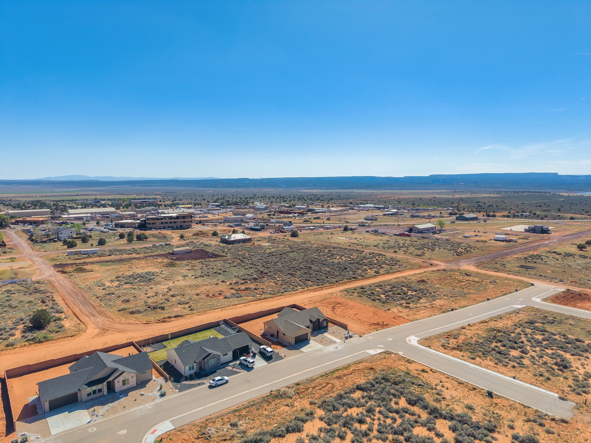 Expansive aerial view showcasing multiple new construction homes with landscaped rear yards