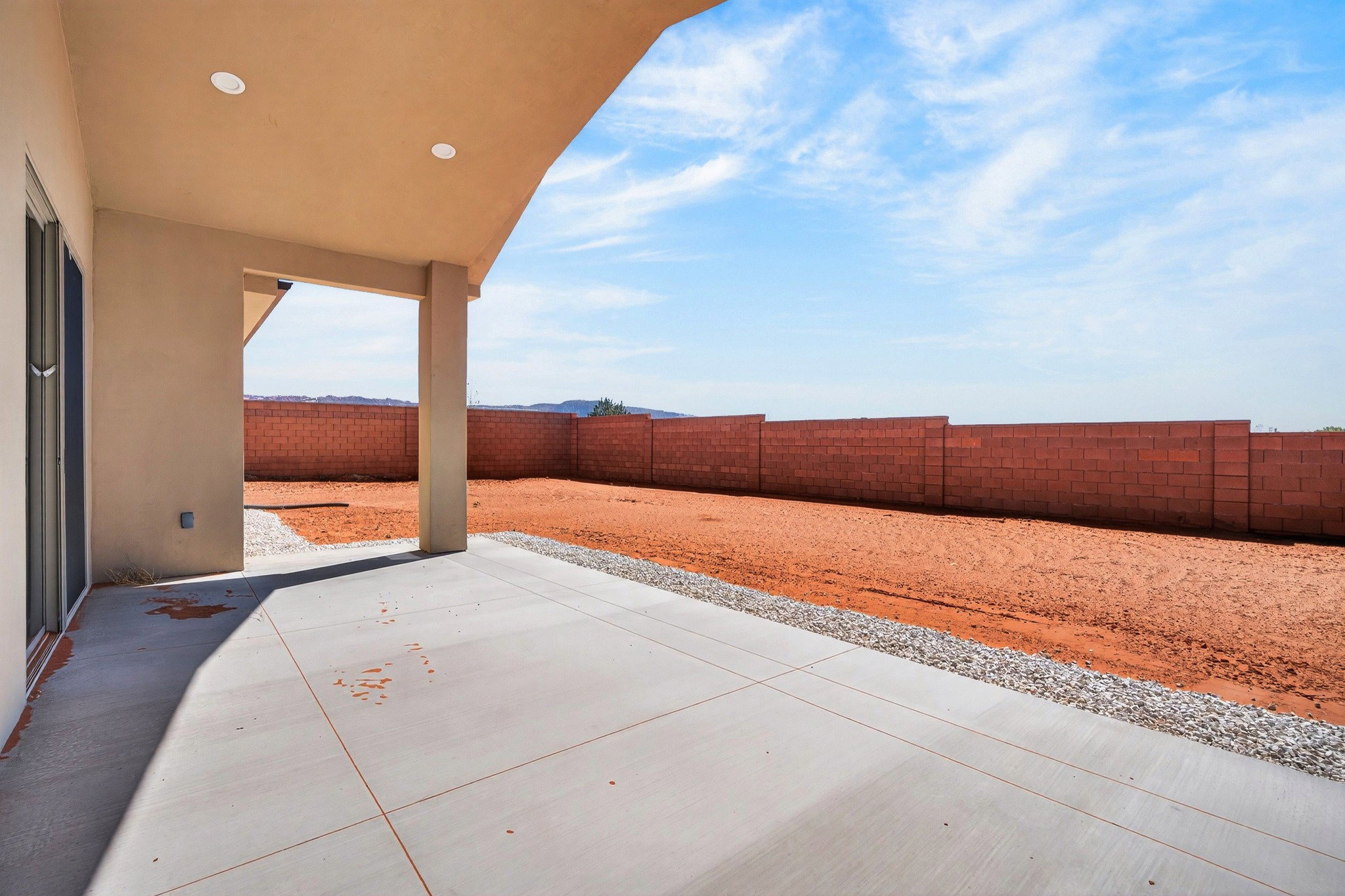 Covered patio featuring recessed lighting, a concrete slab, and an expansive yard space with a block wall perimeter