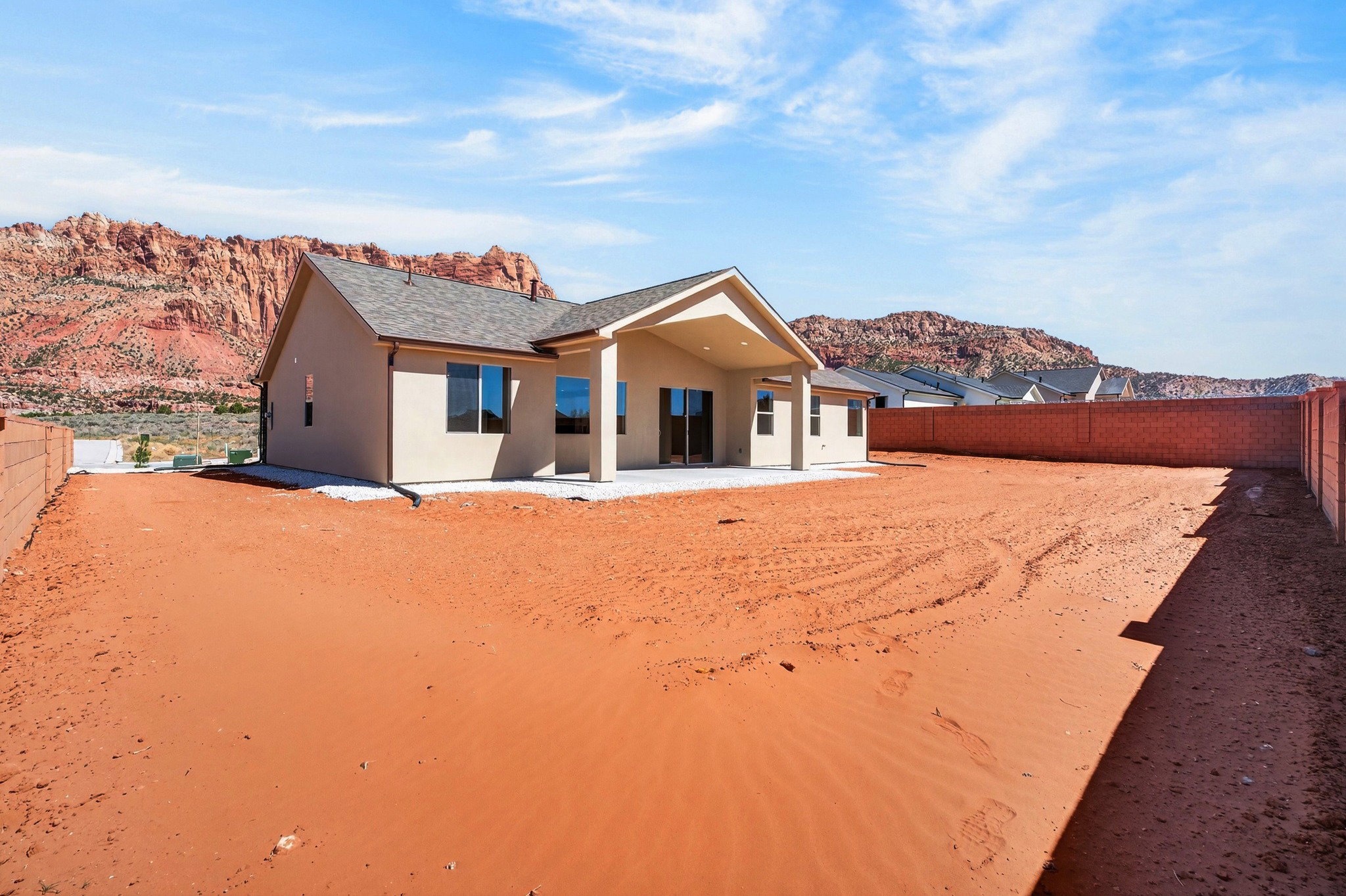 Rear exterior featuring a covered patio, stucco siding, and a composition shingle roof