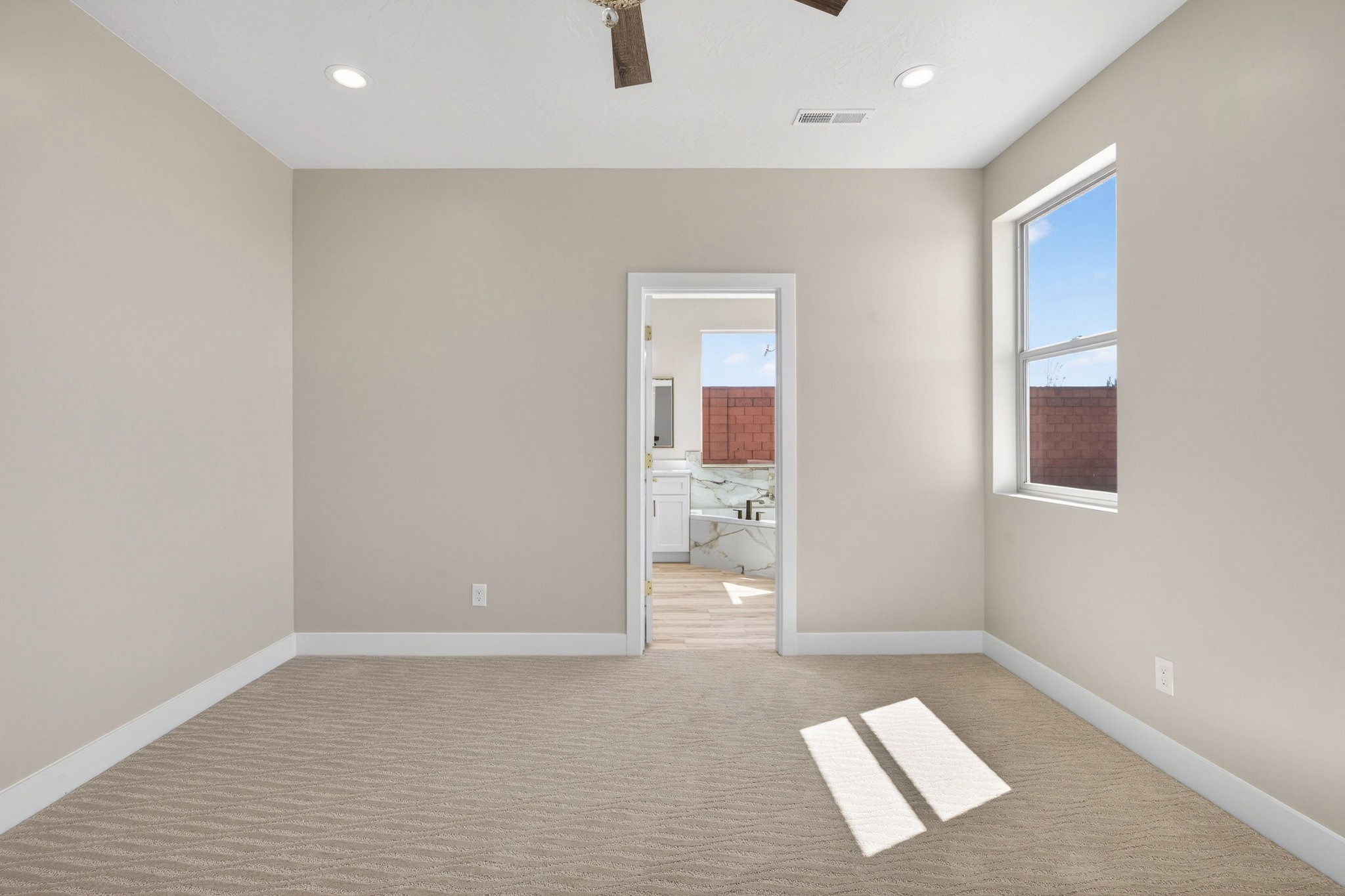 Neutral-toned room with patterned carpeting, recessed lighting, and a ceiling fan