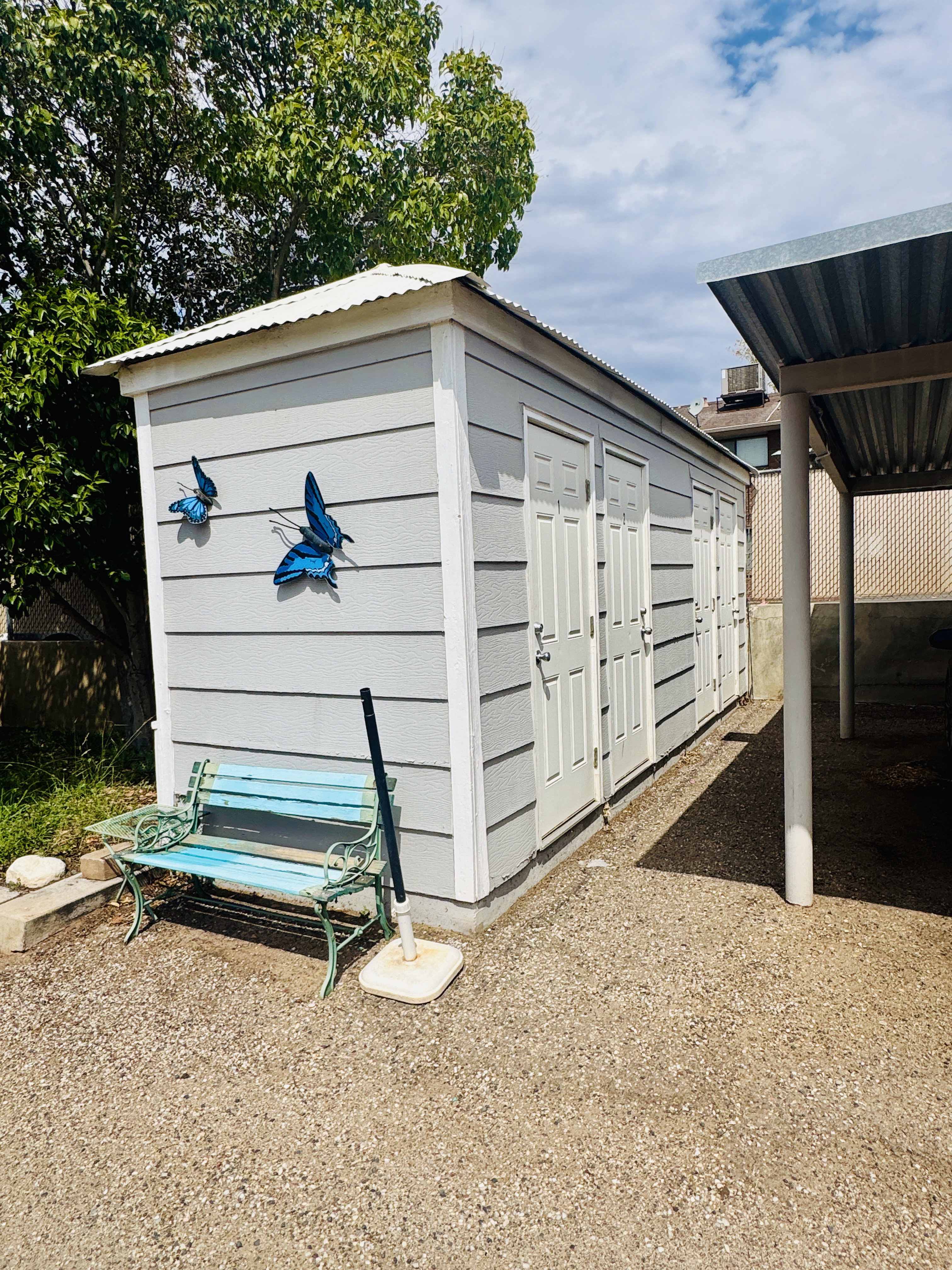 Freestanding outbuilding with horizontal siding and a corrugated metal roof