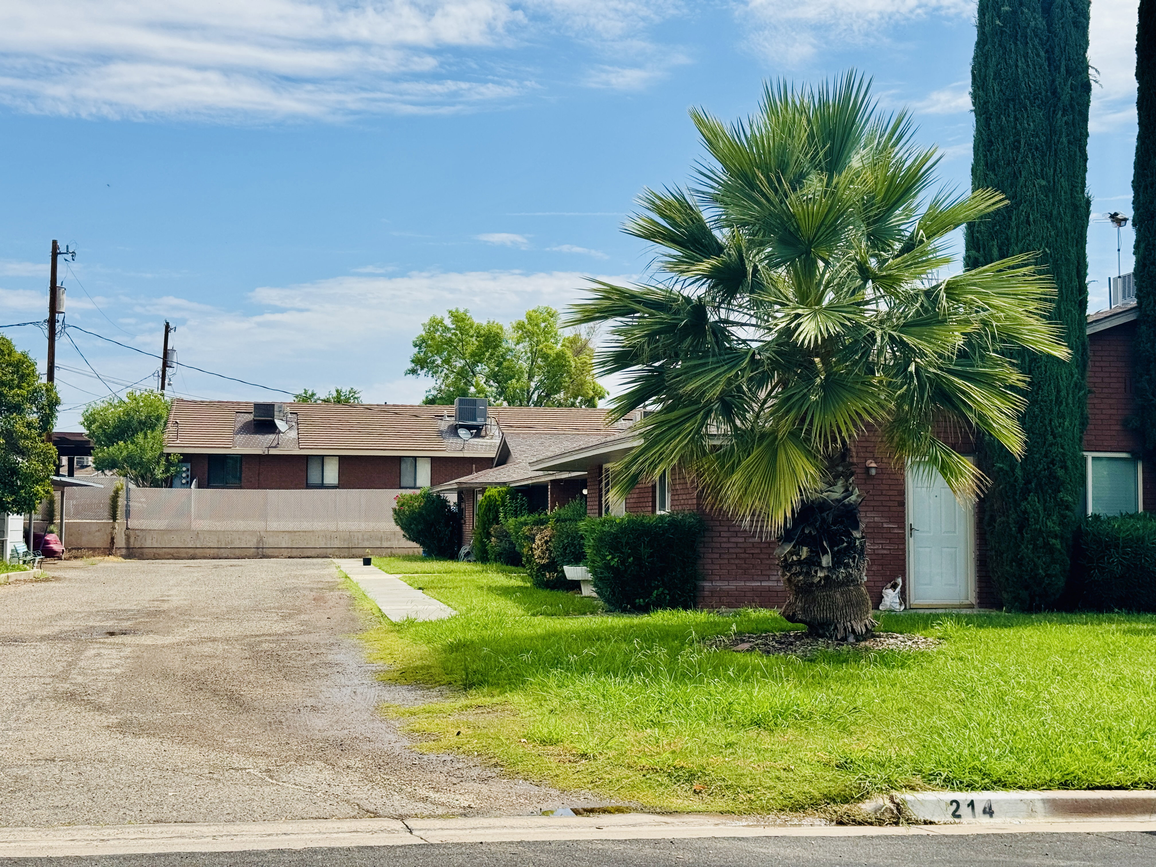 Brick exterior with a mature palm tree and established landscaping