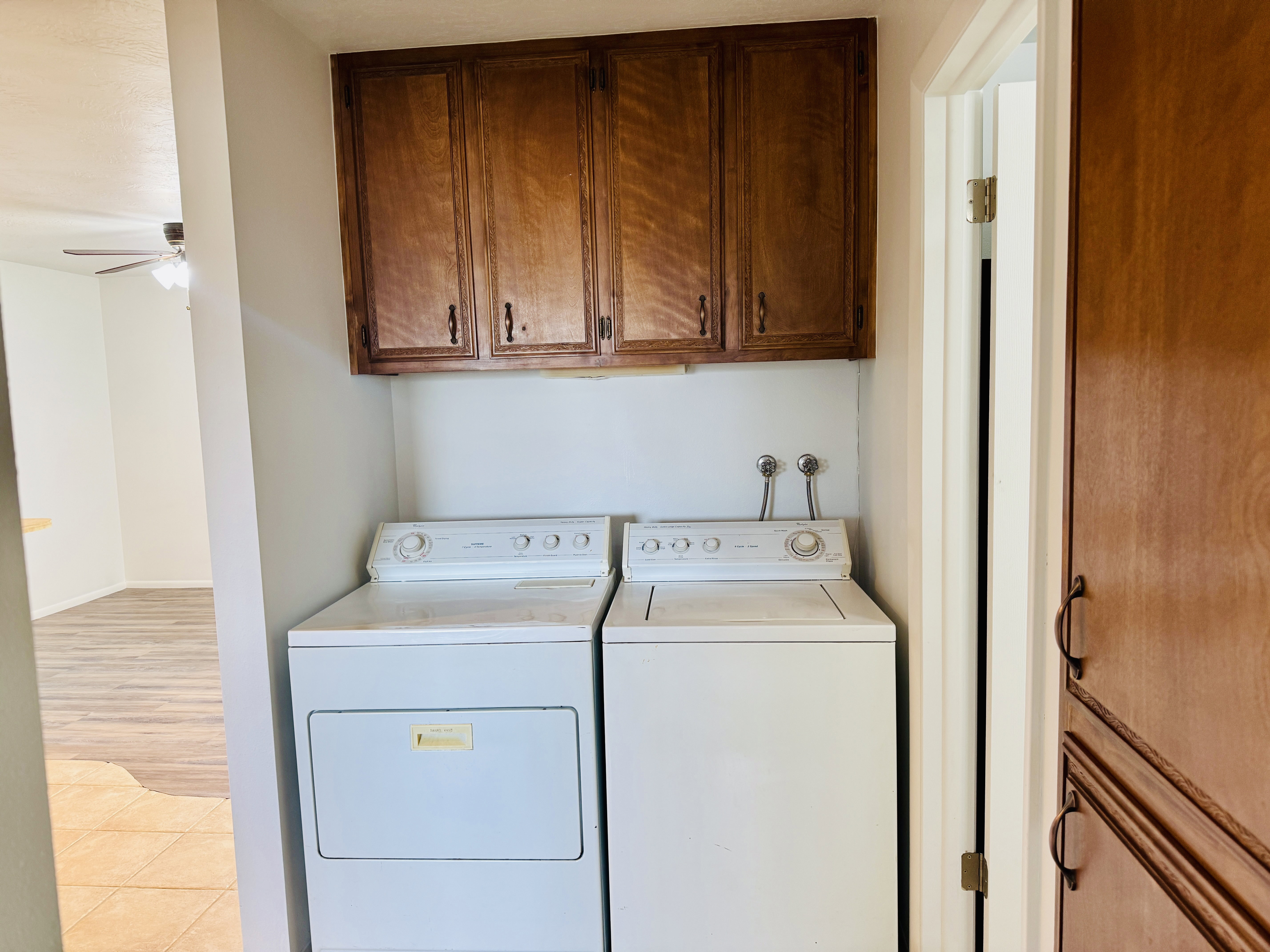 Dedicated laundry area featuring upper wood cabinetry and utility hookups