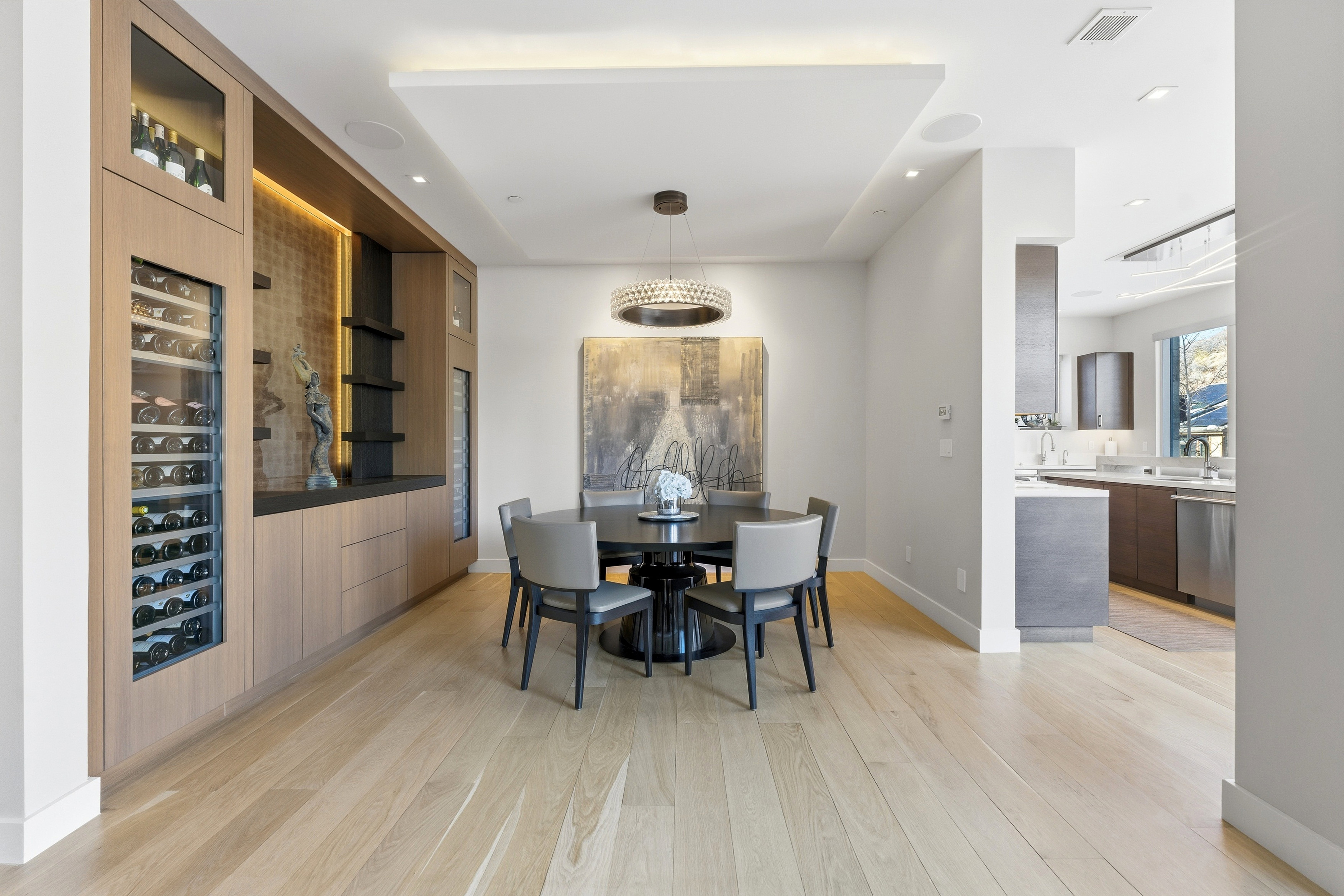 Dining area featuring a built-in custom bar with wine refrigeration, integrated lighting, and a suspended ceiling detail