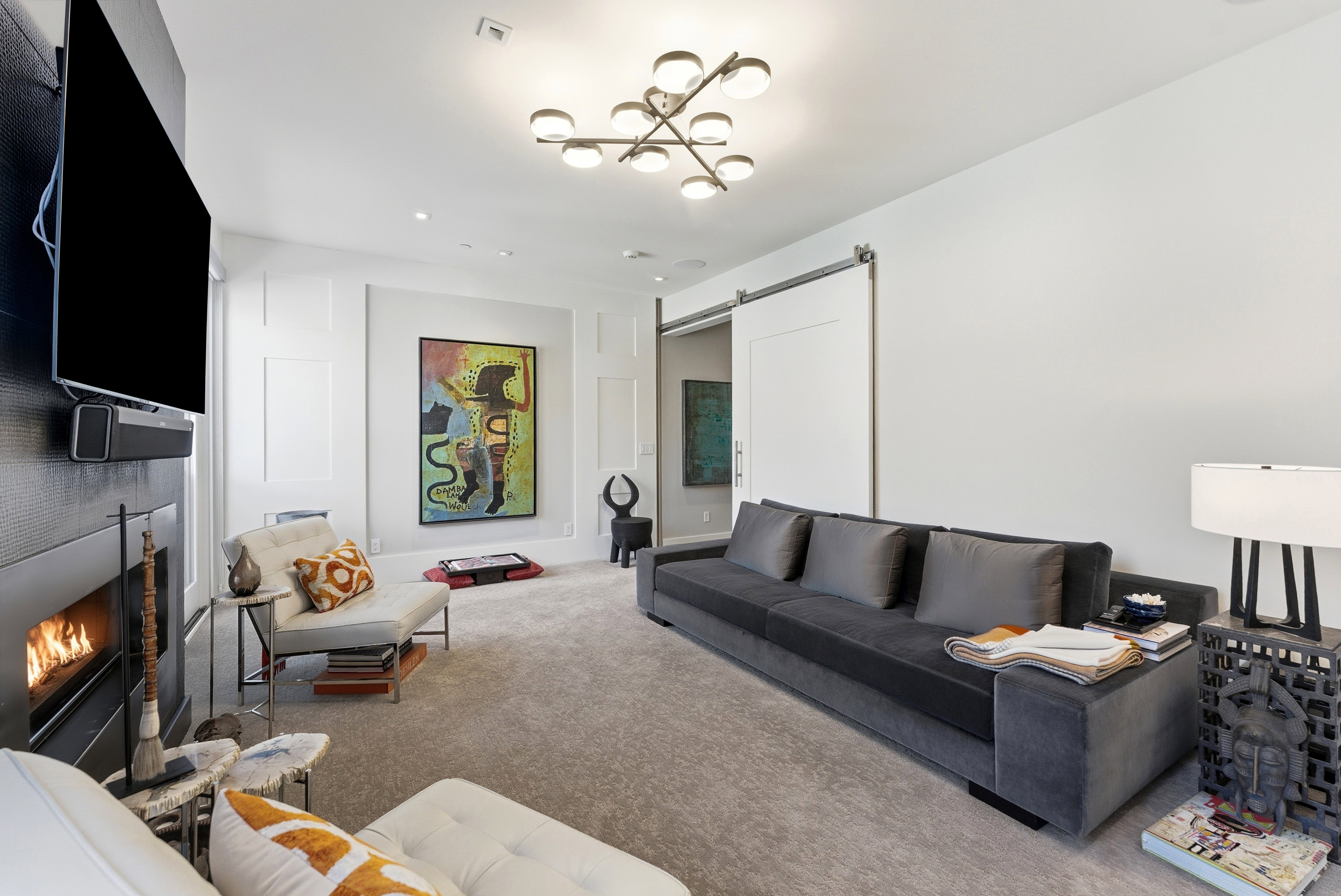 Living area featuring a modern fireplace with a black surround, recessed lighting, and a contemporary ceiling fixture