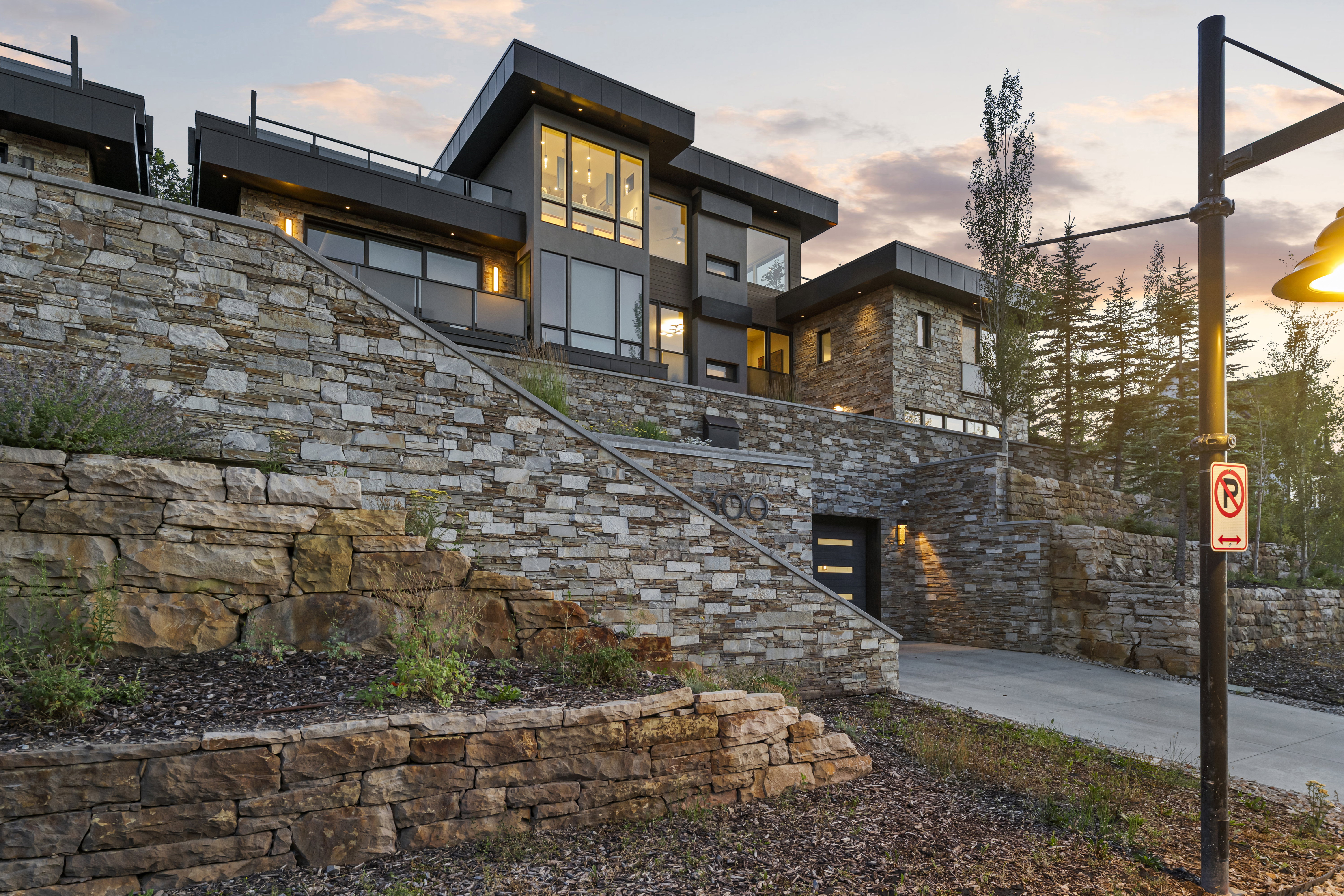Multi-level modern residence featuring extensive stone wall landscaping