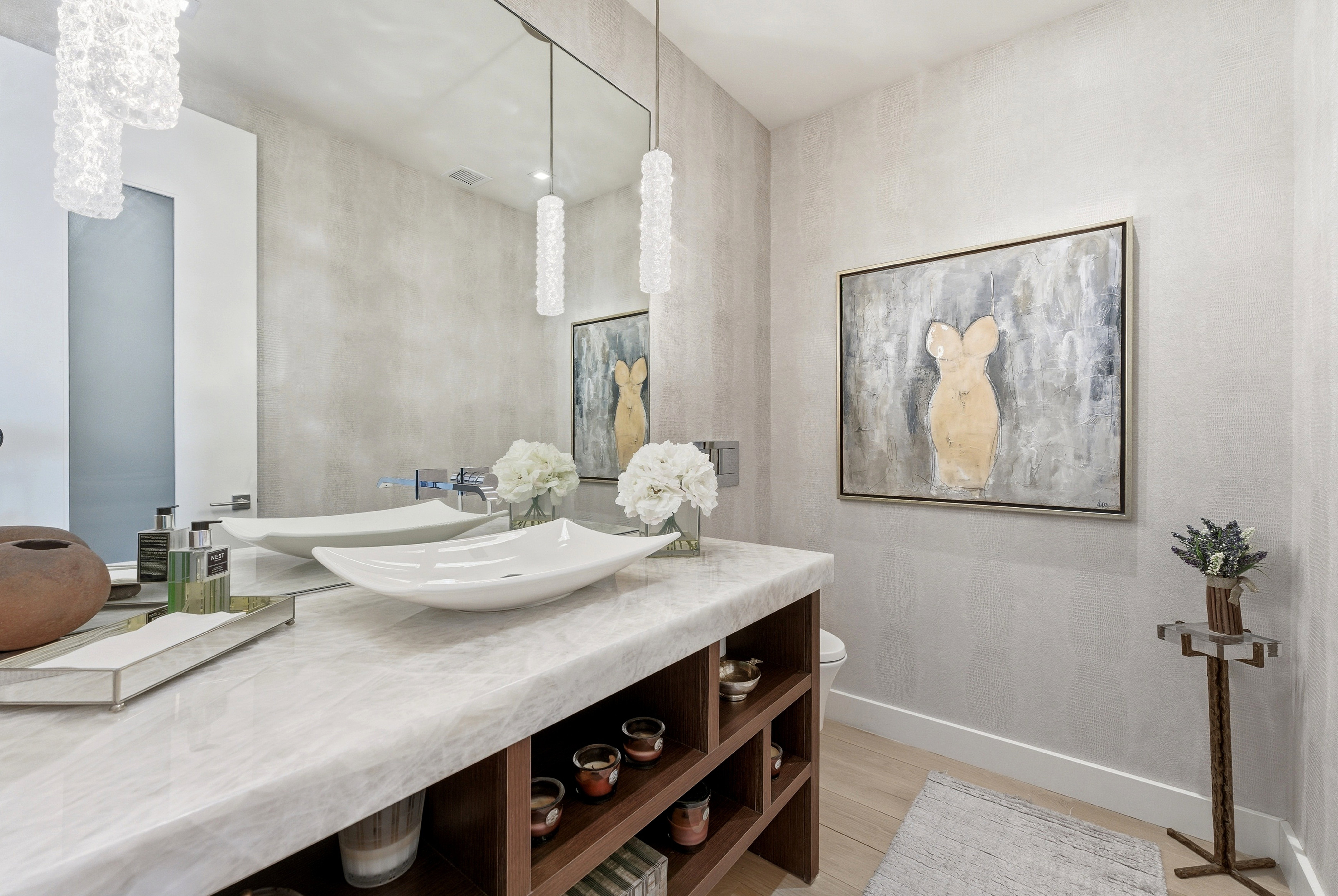 Contemporary vanity featuring a light-toned countertop, dual vessel sinks, and pendant lighting fixtures