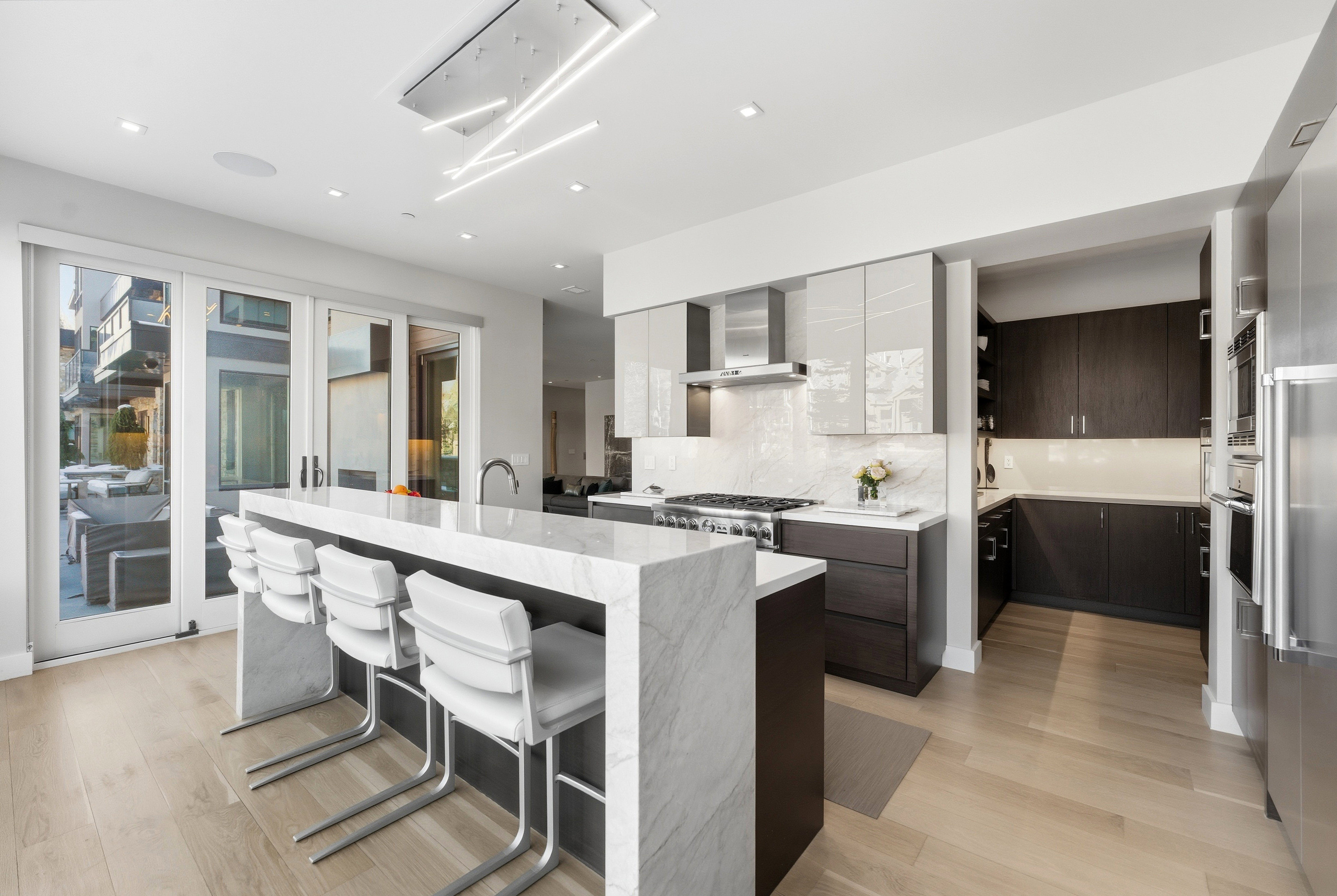 Modern kitchen with a waterfall island featuring a light-toned countertop