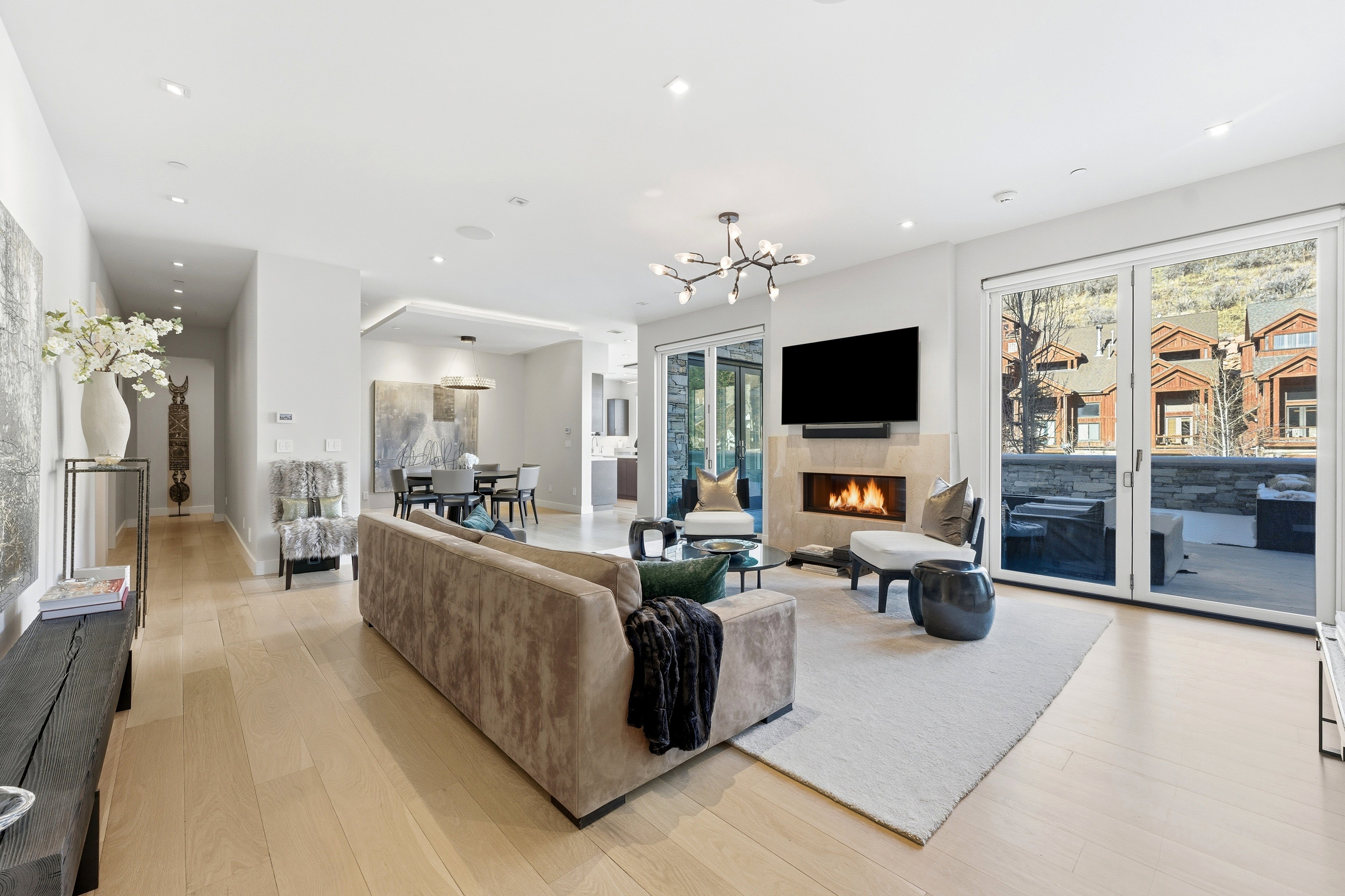 Open-concept living space featuring wood-finish flooring, recessed lighting, and a modern chandelier