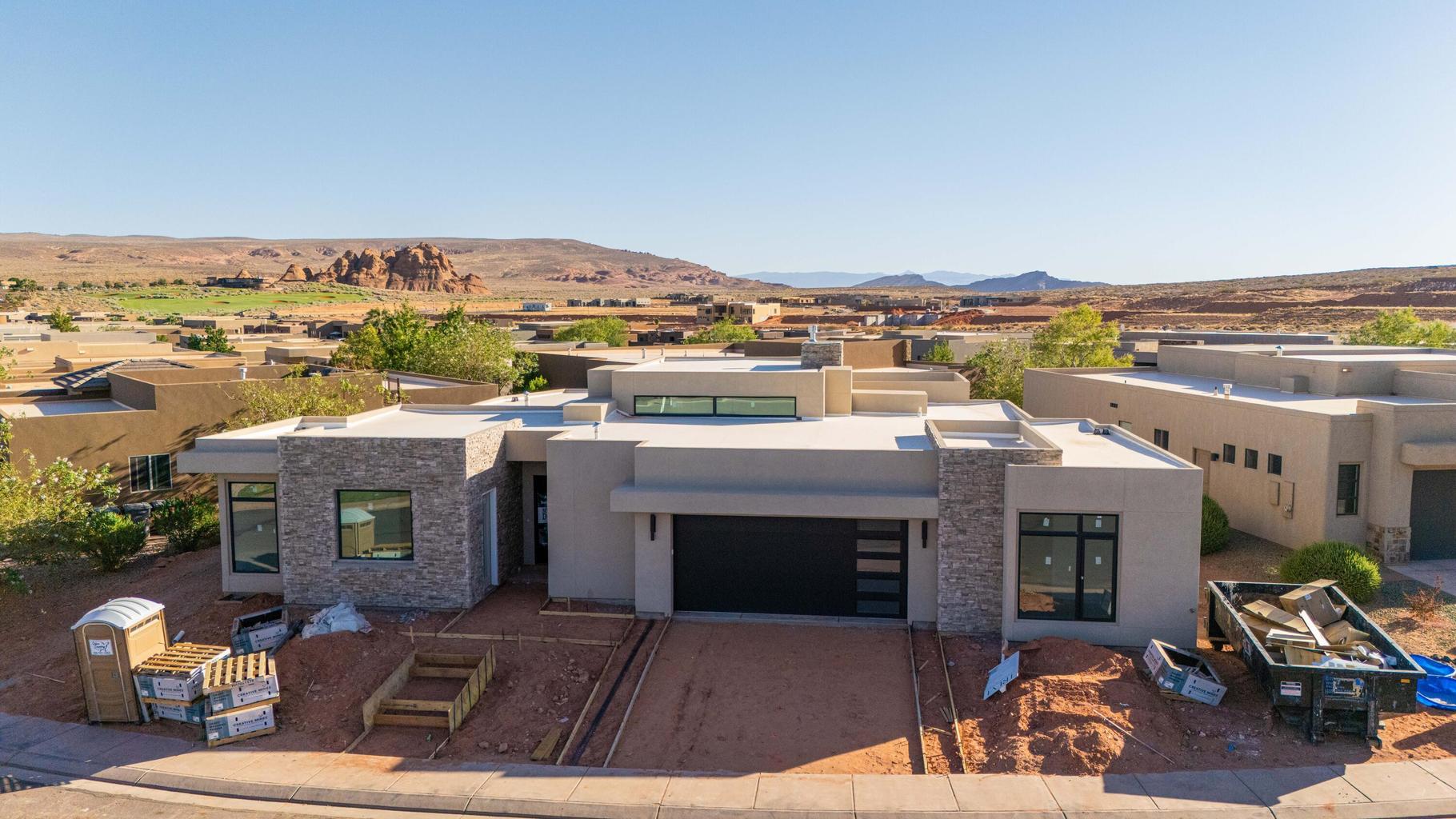 Contemporary architecture featuring a light-toned stucco exterior and stacked stone accents