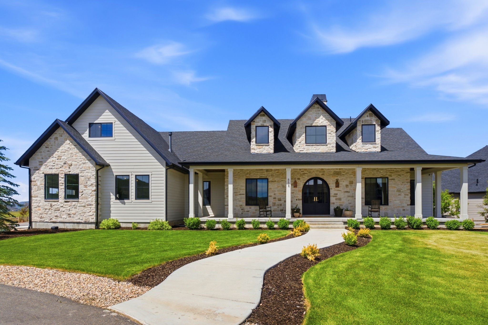 Stone and siding exterior with a dark shingle roof