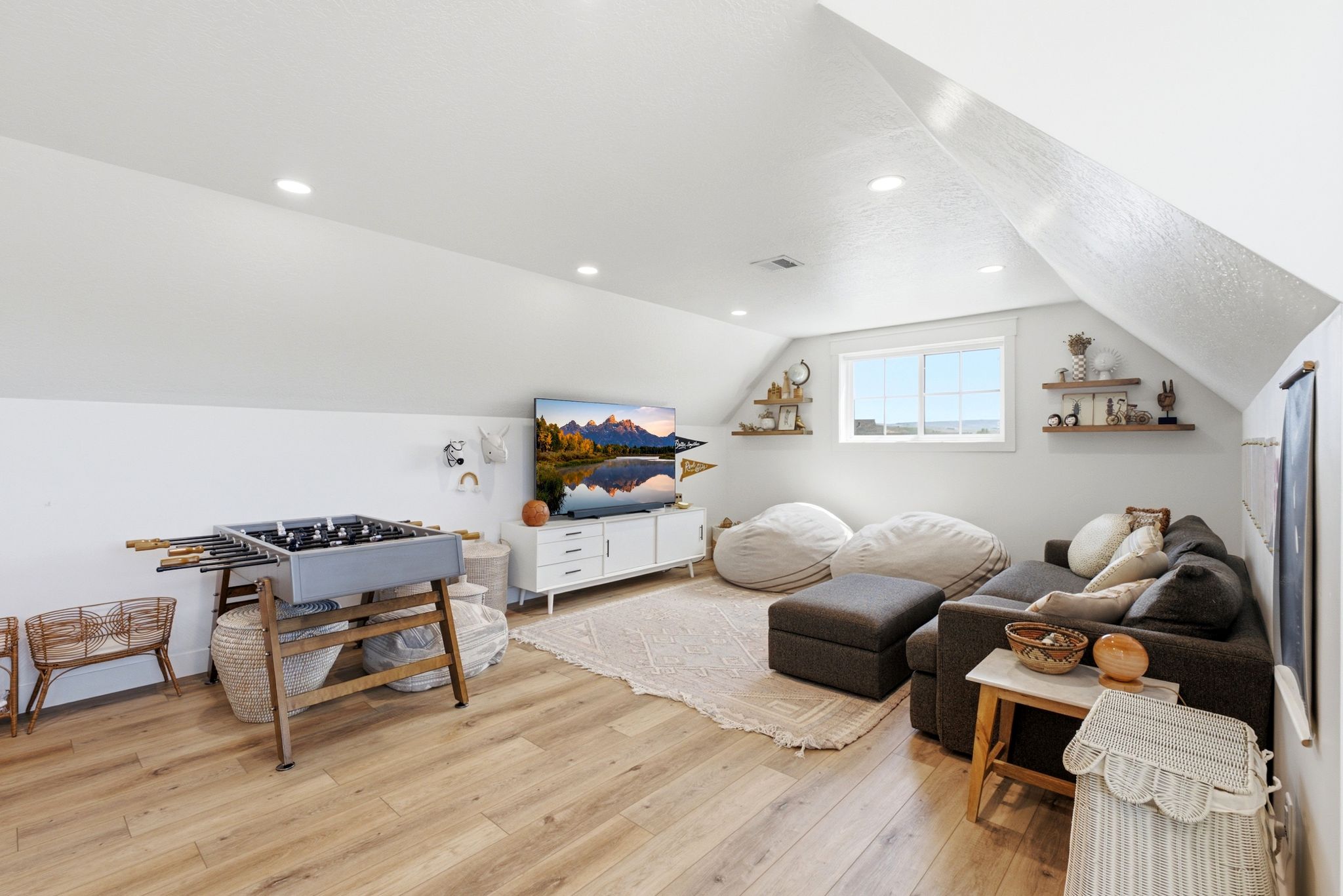 Spacious bonus room featuring wood-finish flooring, recessed lighting, and a window providing natural illumination