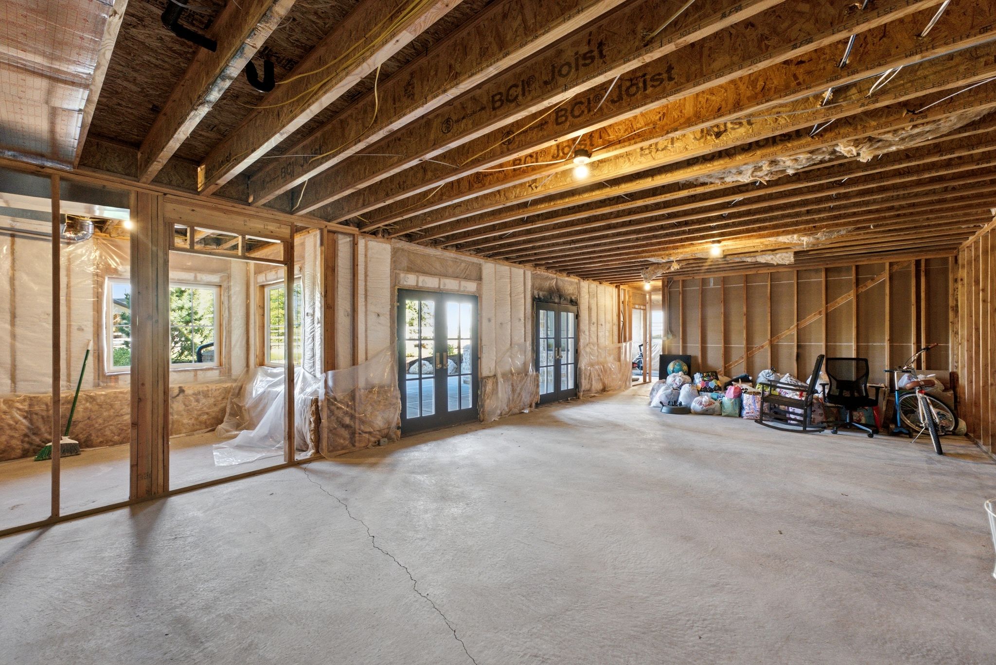 Unfinished lower level featuring exposed ceiling joists, concrete flooring, and framed interior walls