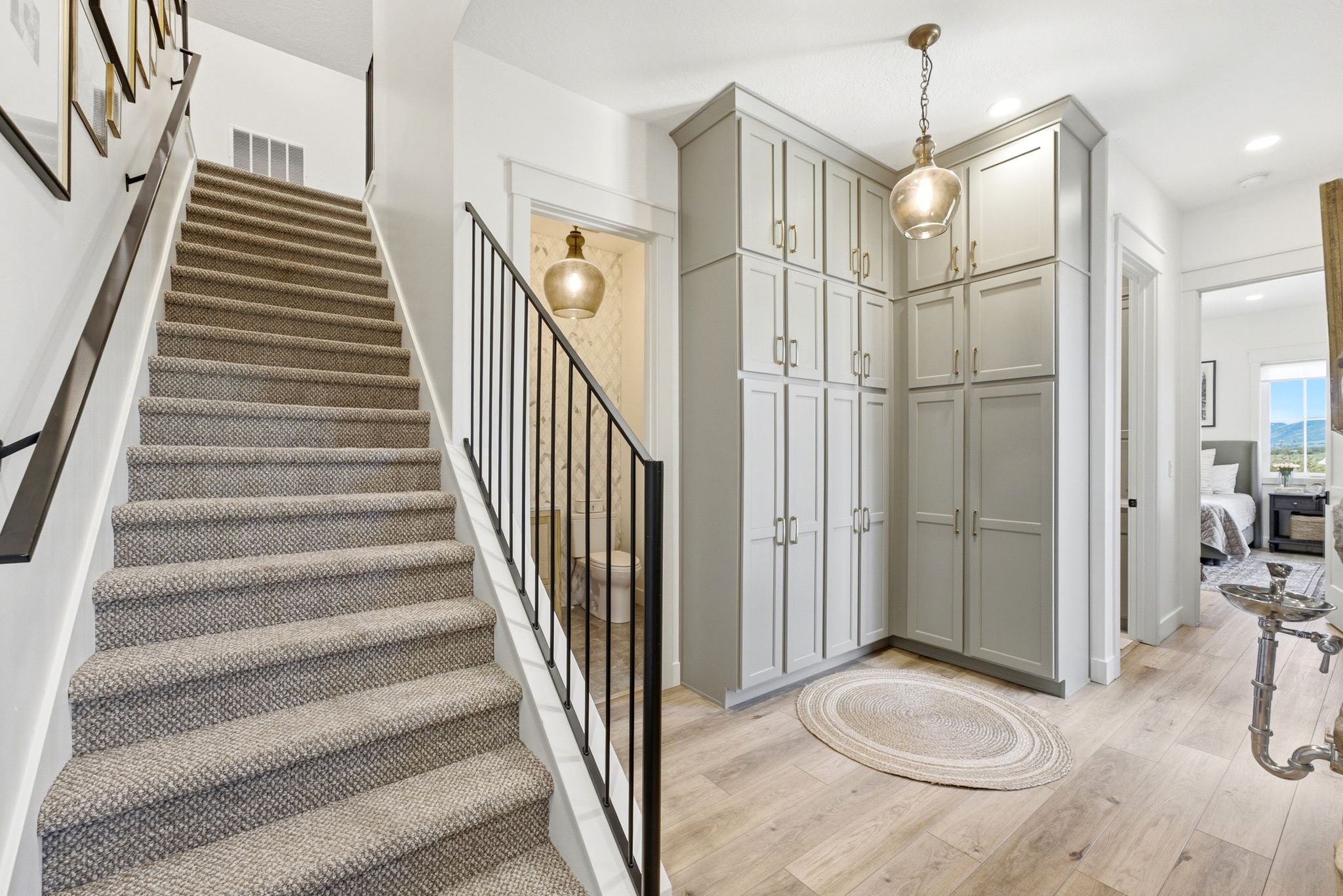 Staircase featuring carpeted treads and black metal railings