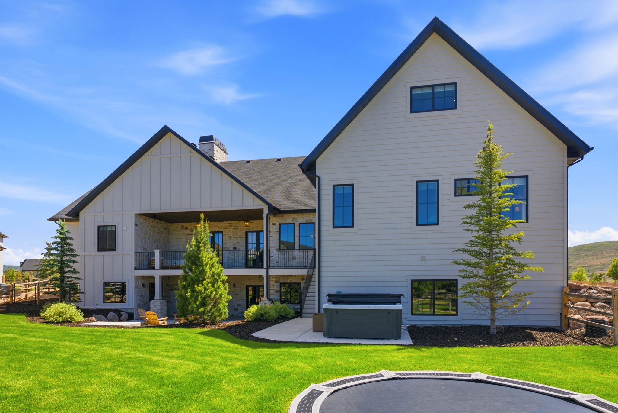 Rear exterior showcasing multi-level architecture with a covered patio and a separate covered balcony
