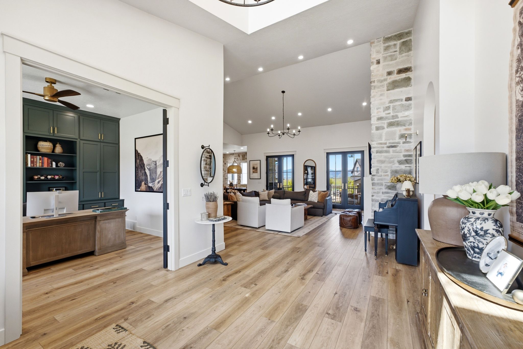 Spacious main hallway with wood-finish flooring, vaulted ceiling, and recessed lighting
