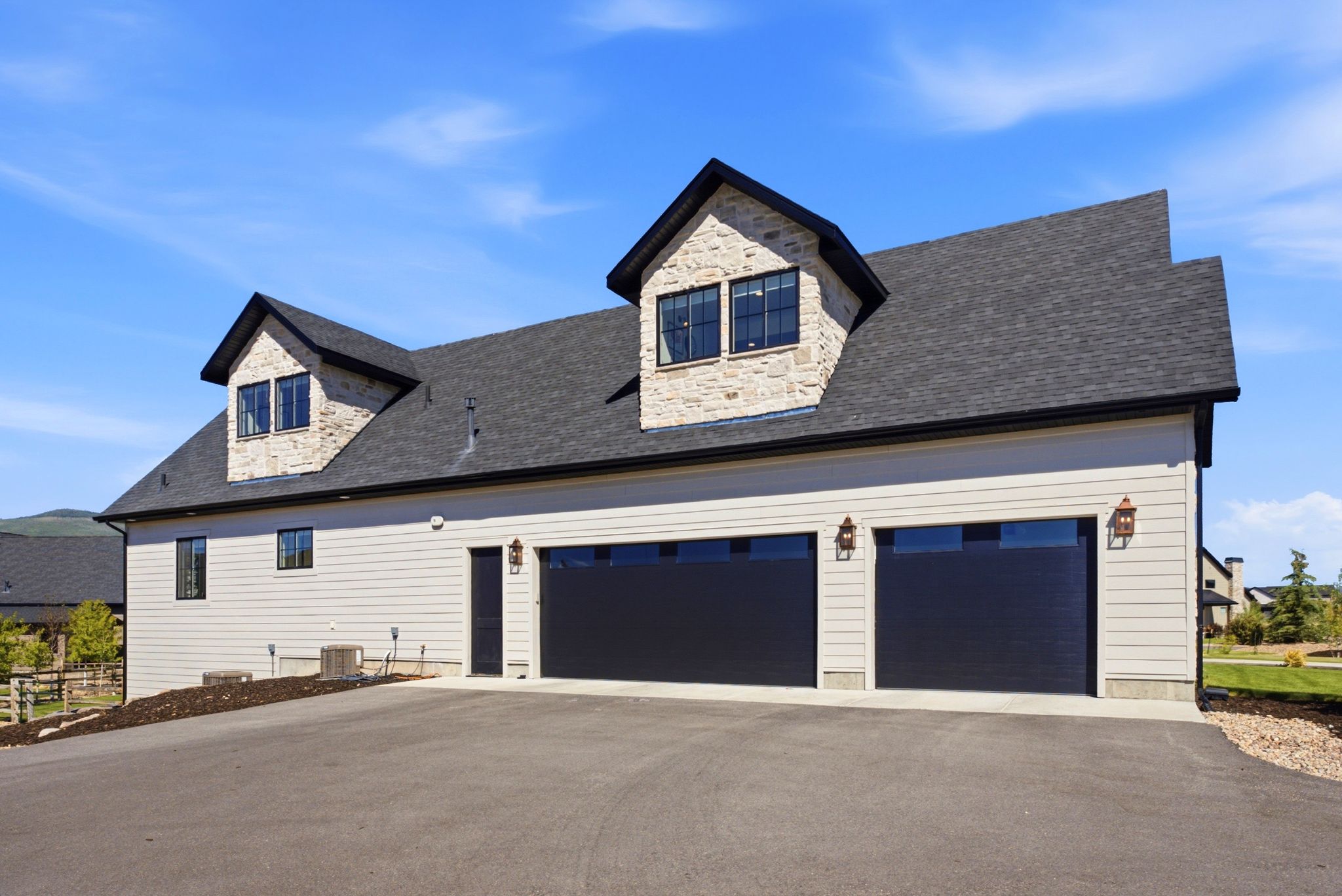 Two-car garage with black doors and decorative sconces