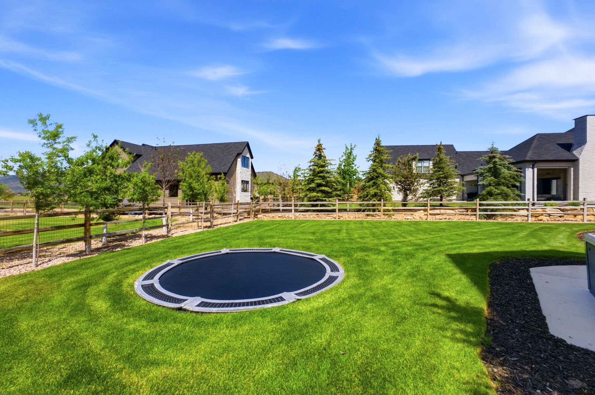 Expansive green lawn featuring an in-ground trampoline
