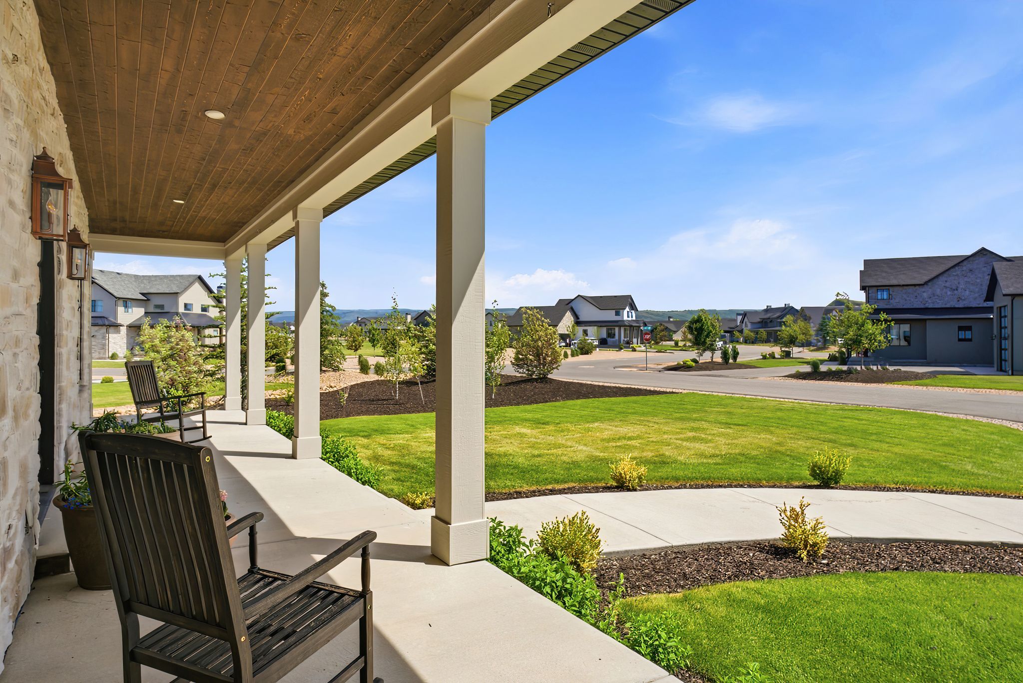 Covered front porch featuring a wood-finish ceiling, recessed lighting, and stone veneer exterior