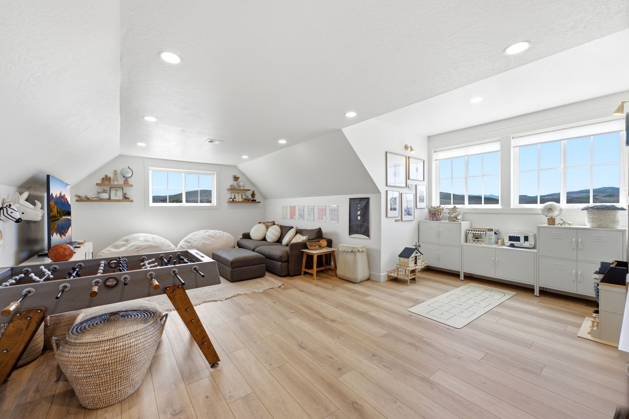 Spacious bonus room featuring light wood-finish flooring, recessed lighting, and multiple windows