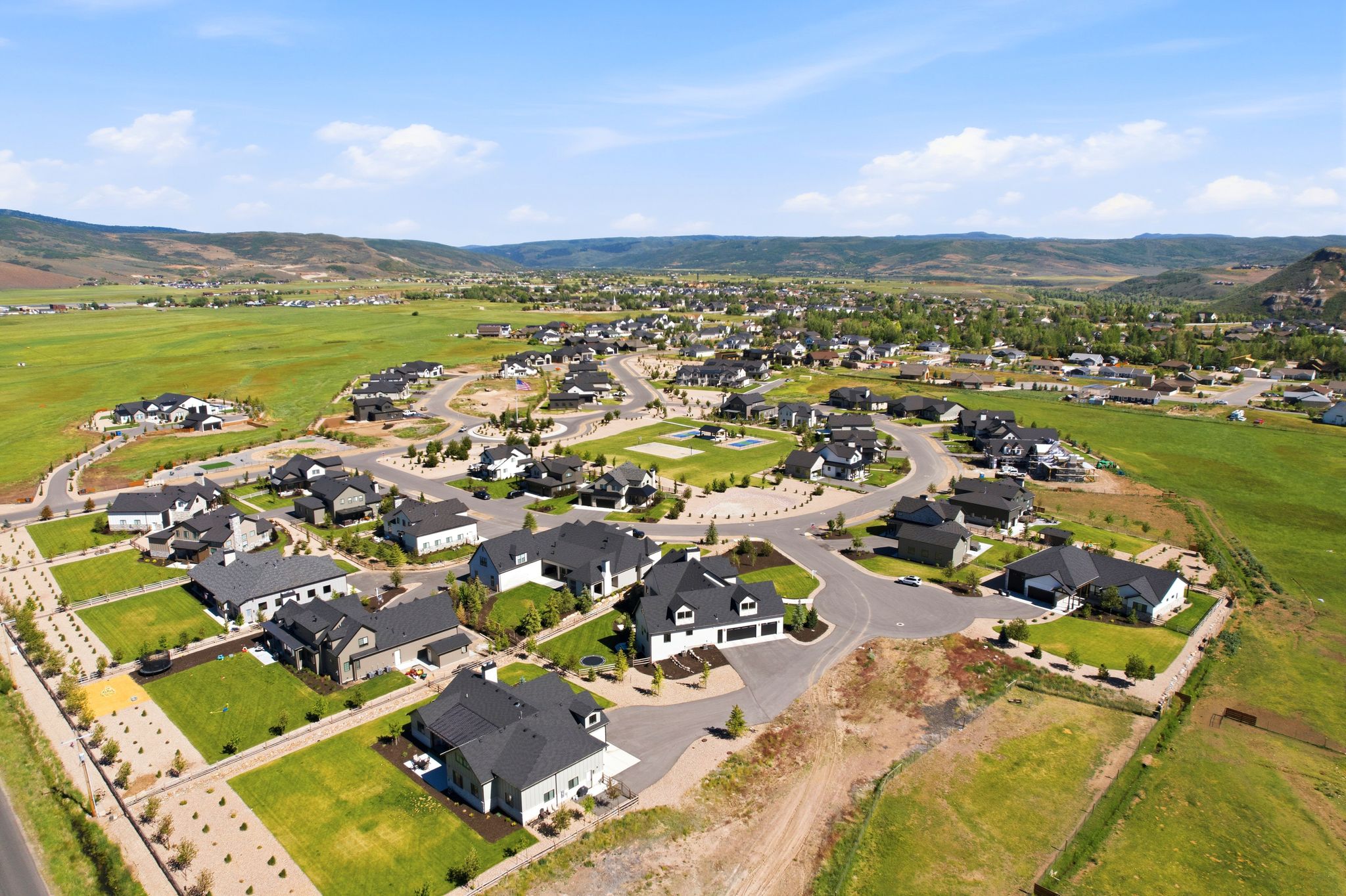 Expansive residential development featuring a collection of modern homes with dark asphalt shingle roofs