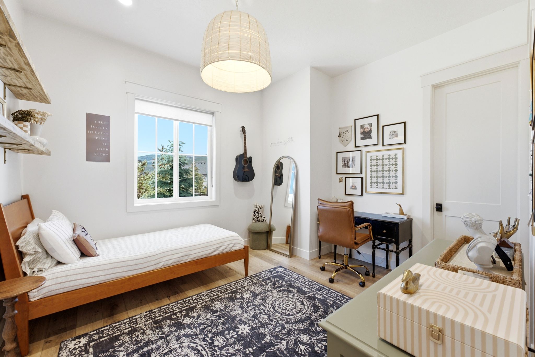 Bright interior space featuring a window with exterior landscape, wood-finish flooring, and a contemporary pendant light fixture