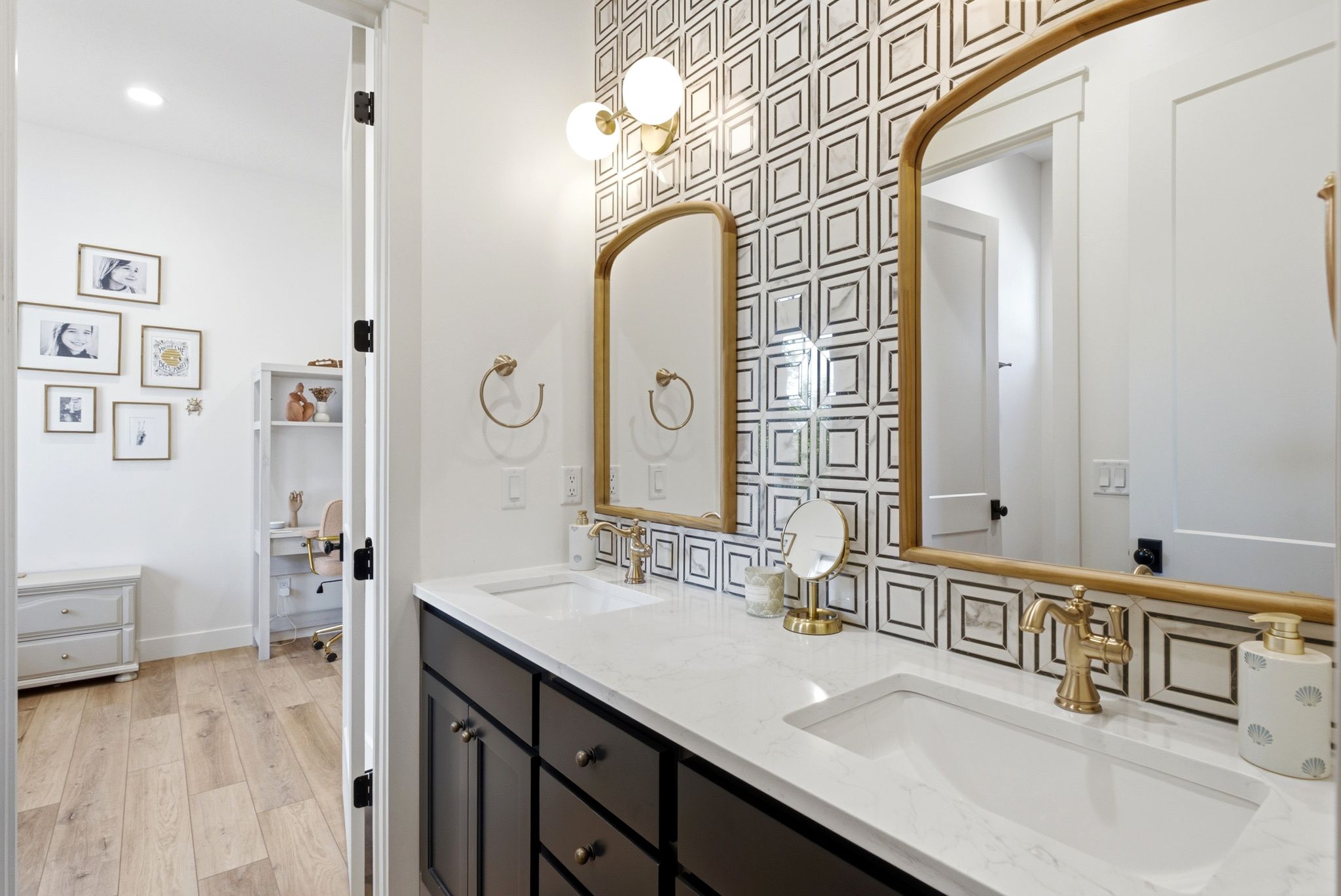 Bathroom vanity featuring dual under-mount sinks, a white countertop, and gold-finish fixtures