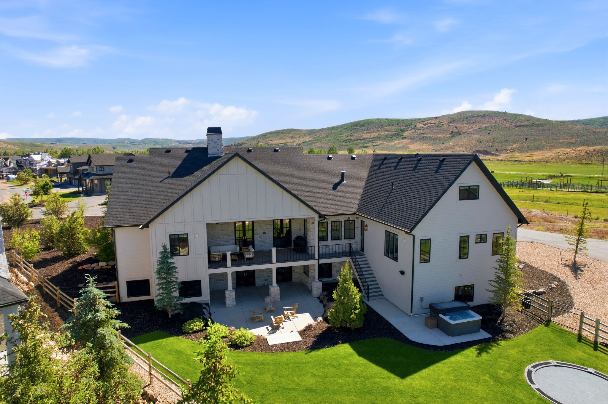 Modern farmhouse-style residence with a two-story back patio and covered deck
