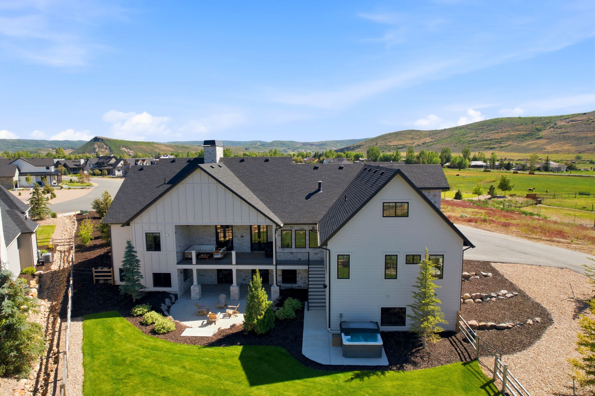 Modern farmhouse exterior featuring a black shingle roof and white siding