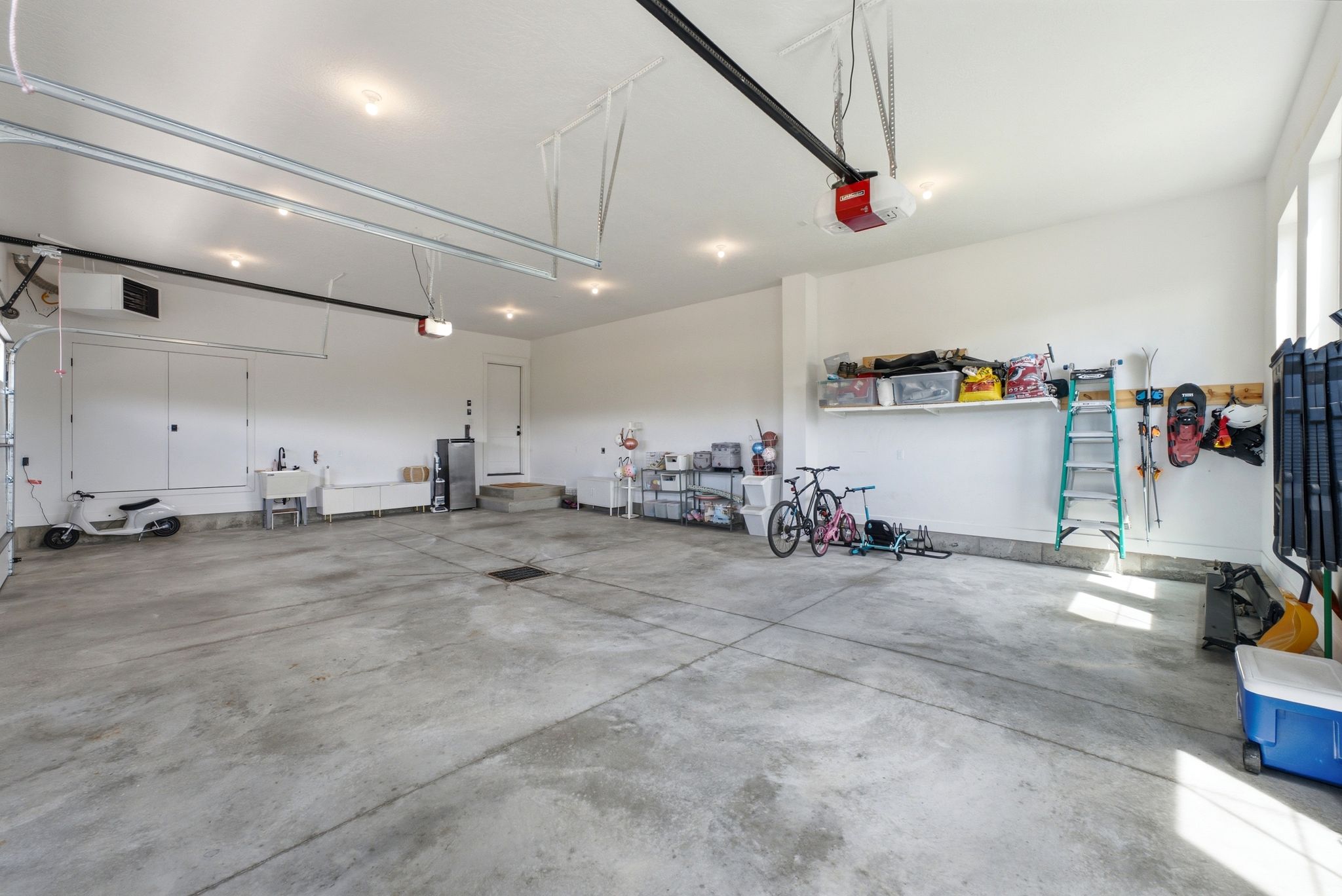 Spacious garage featuring a concrete floor, bright white walls, and recessed lighting