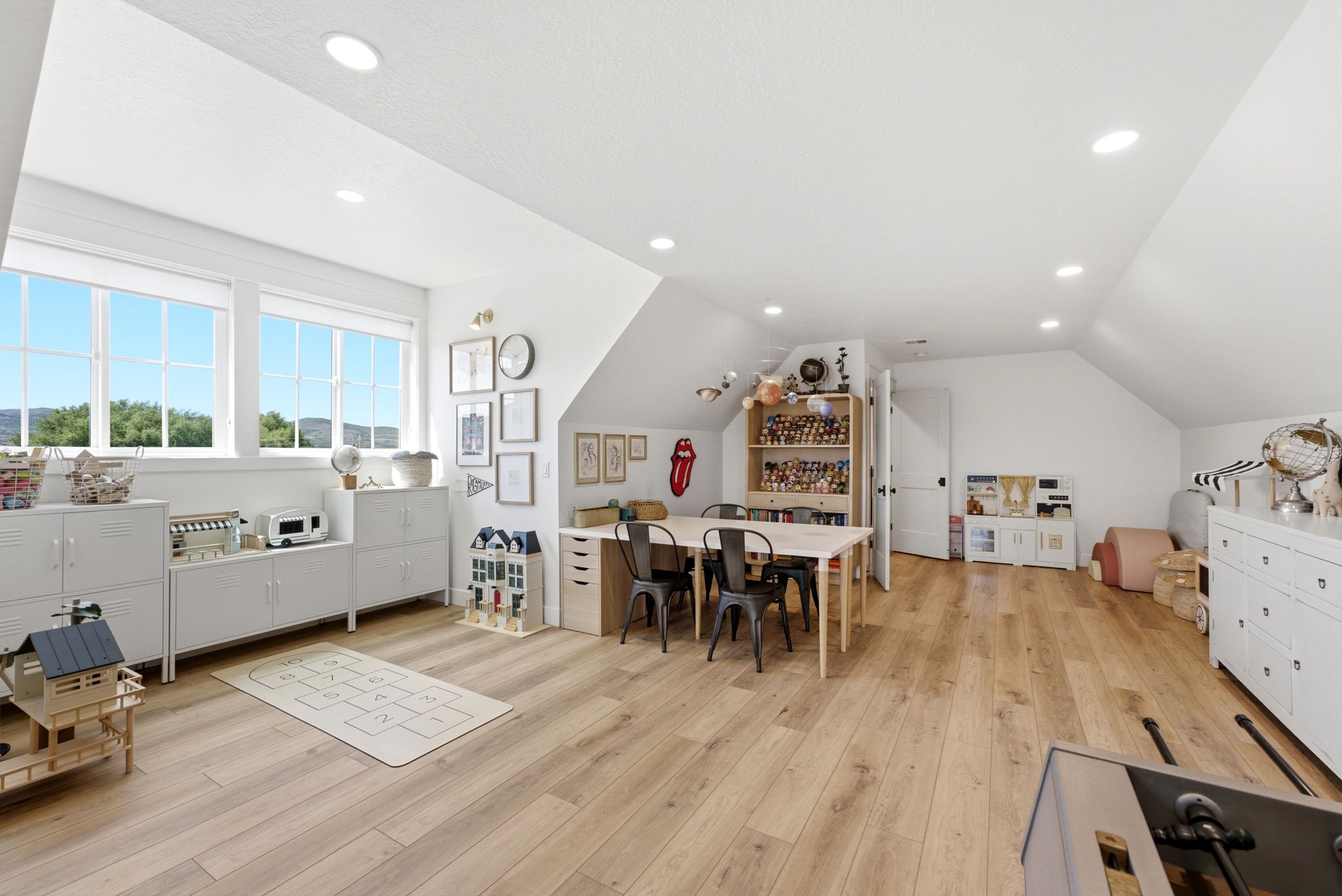 Spacious room featuring light wood-finish flooring, recessed lighting, and multiple windows