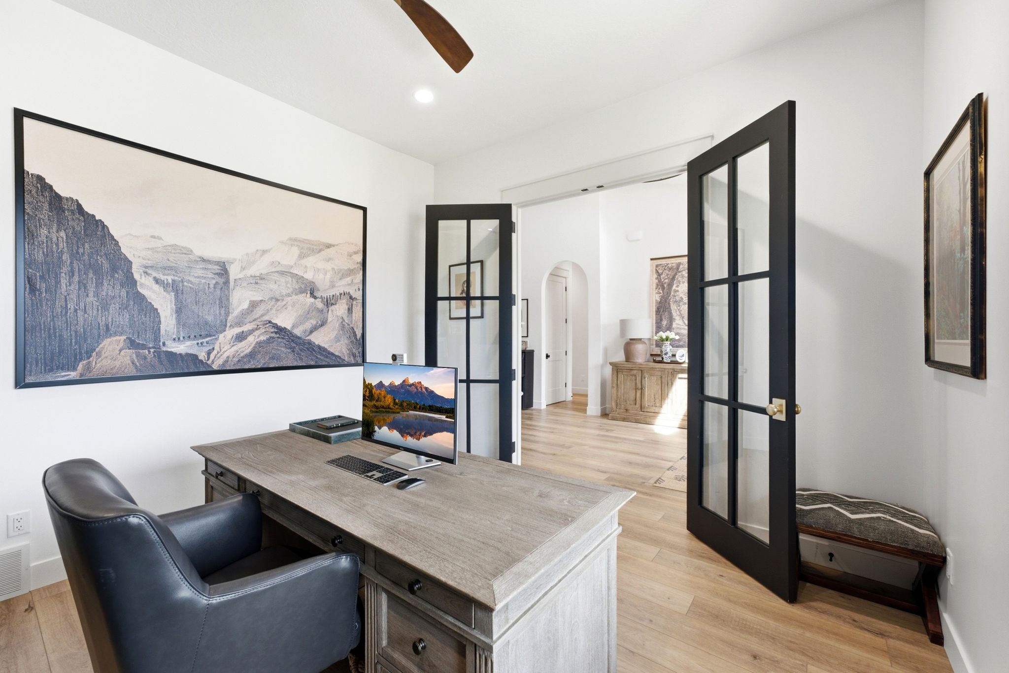 Room featuring wood-finish flooring, white walls, and a ceiling fan