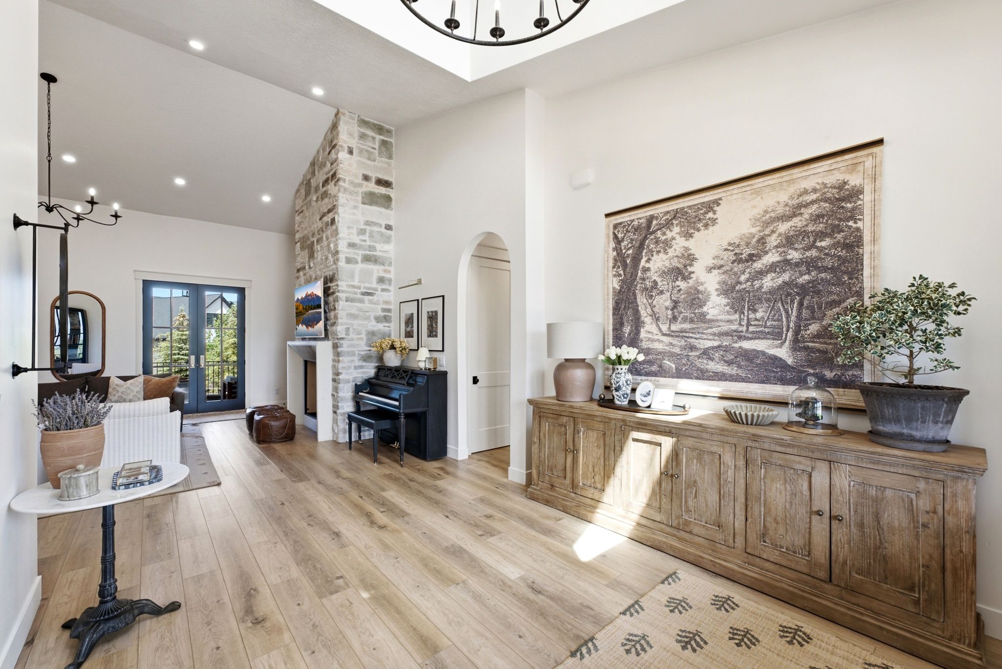 Spacious interior featuring wood-finish flooring, a vaulted ceiling with a large skylight, and recessed lighting