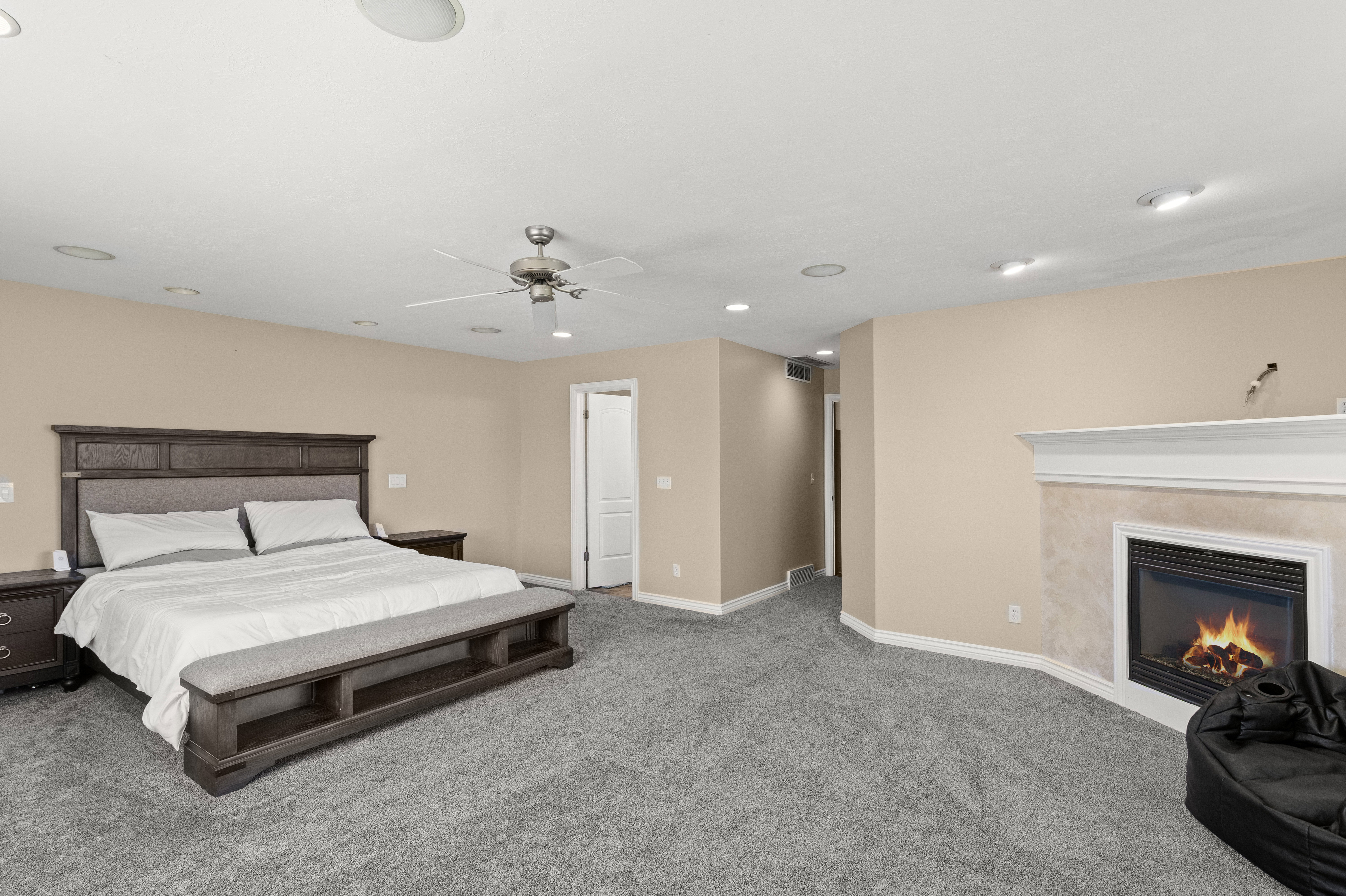 Spacious bedroom featuring neutral wall tones, recessed lighting, and grey carpeting