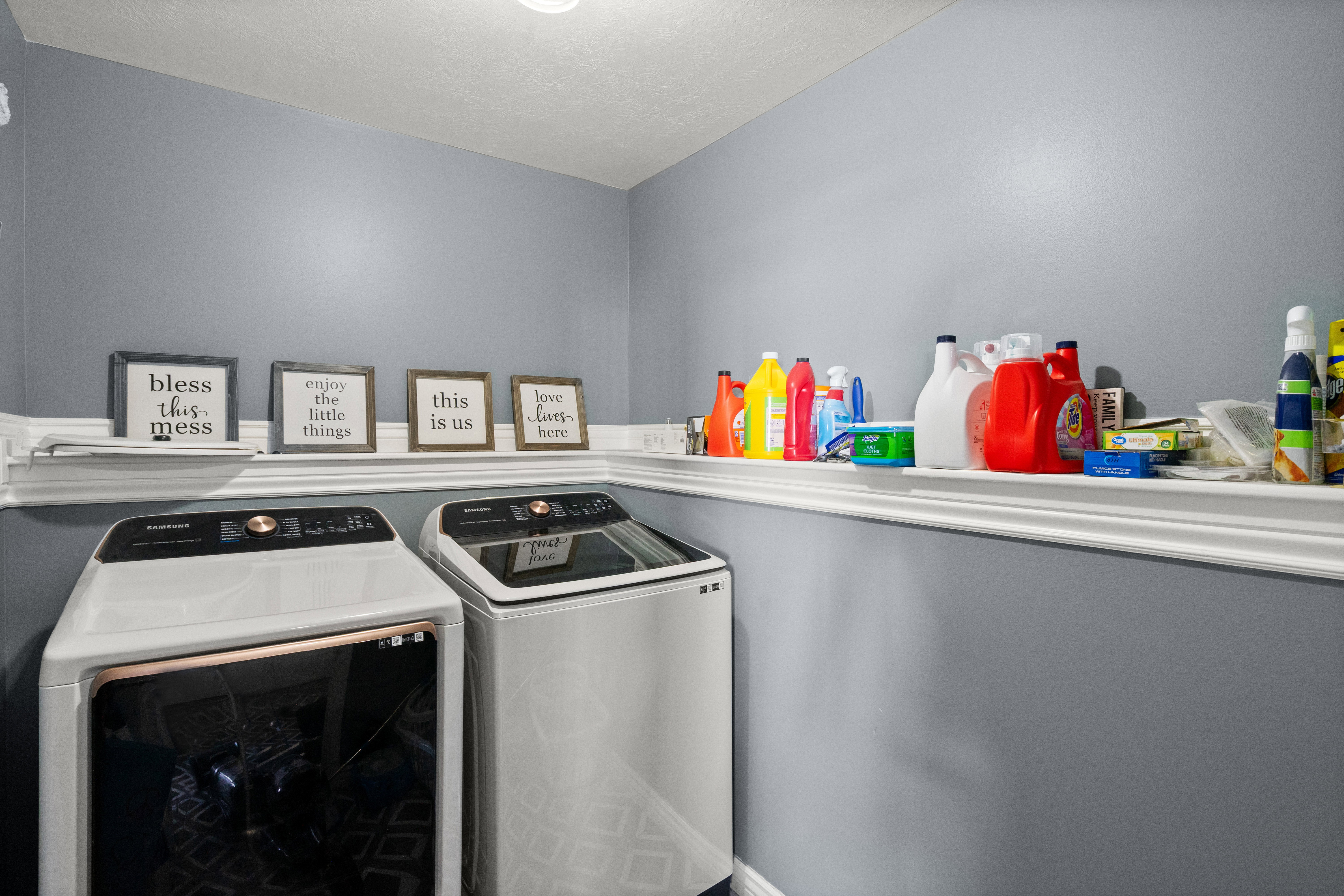 Dedicated laundry area featuring a light blue wall color, white trim, and a built-in display ledge