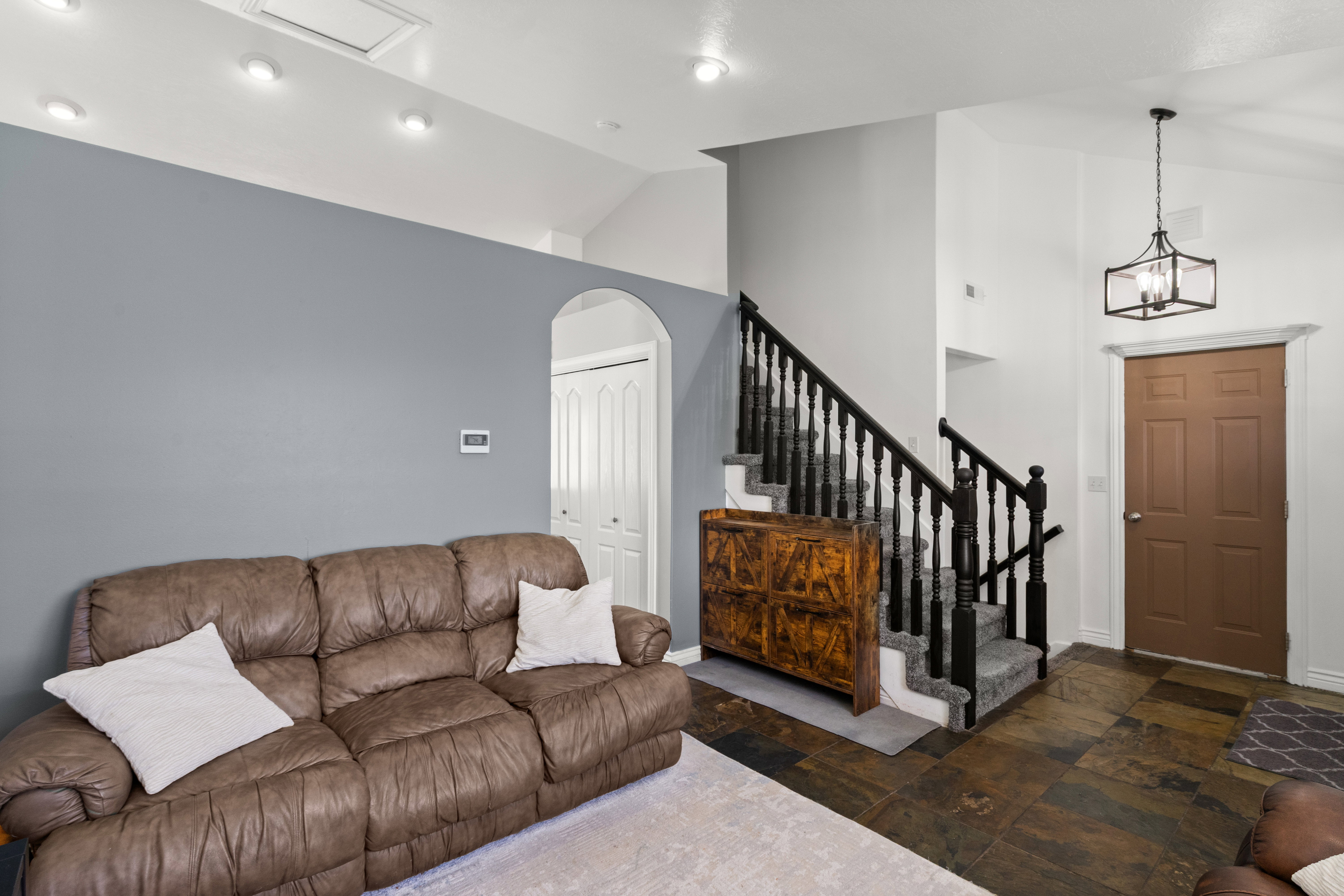 Vaulted ceilings highlighting recessed lighting and a contemporary caged pendant light fixture