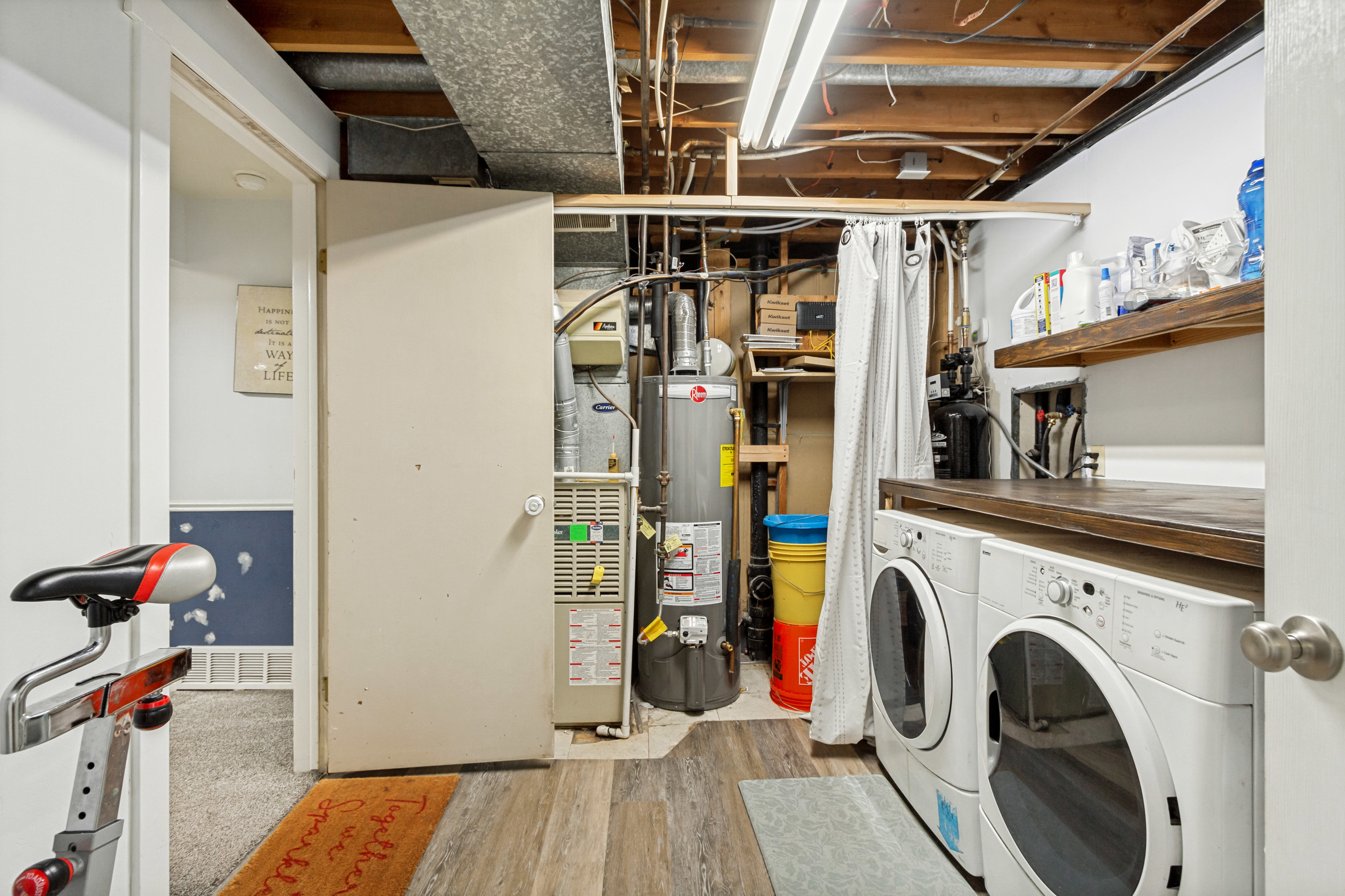 Dedicated laundry space featuring a wood-finish countertop and two wall-mounted wood shelves