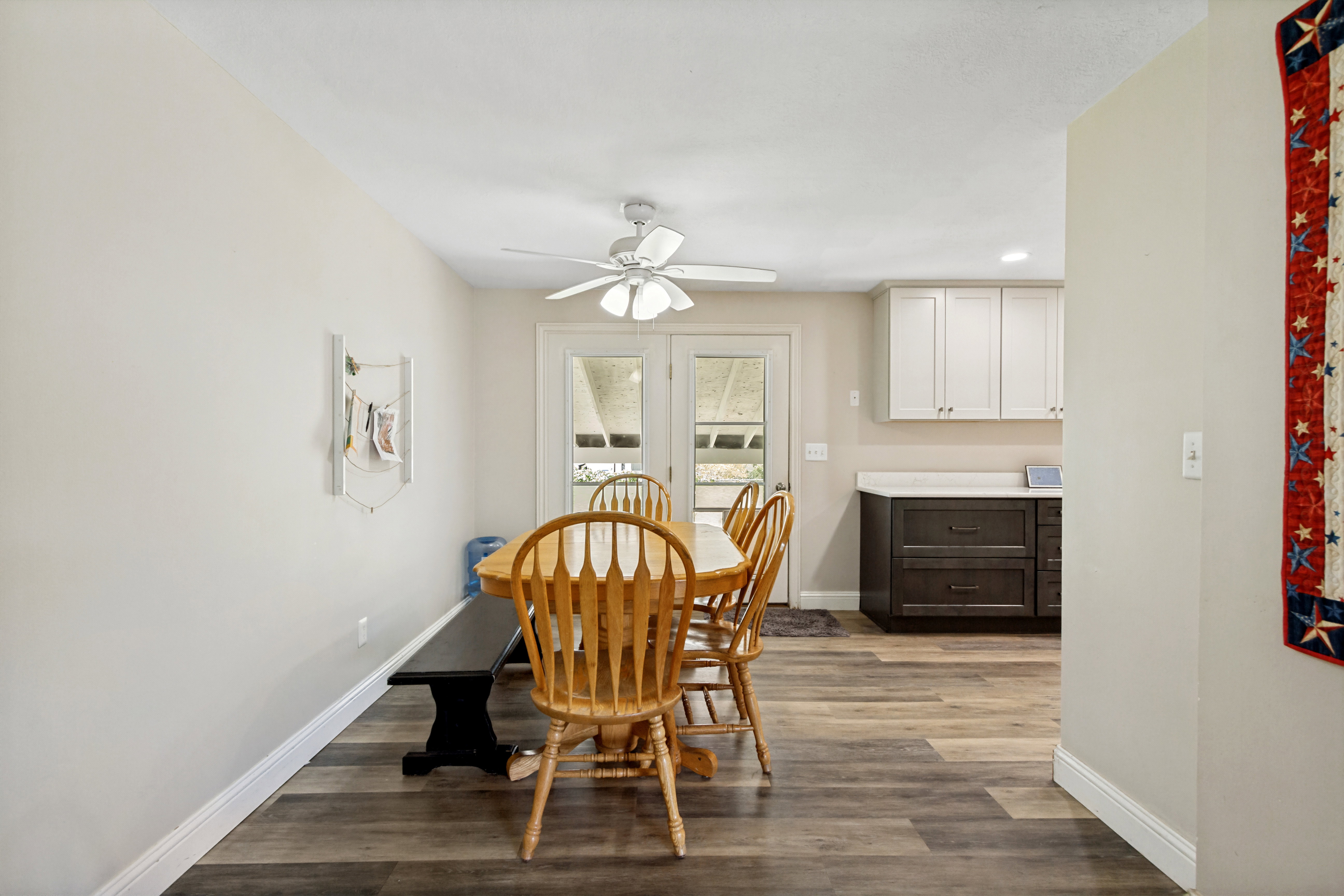 Dining area featuring wood-finish flooring, light-toned walls, and a ceiling fan with integrated lighting