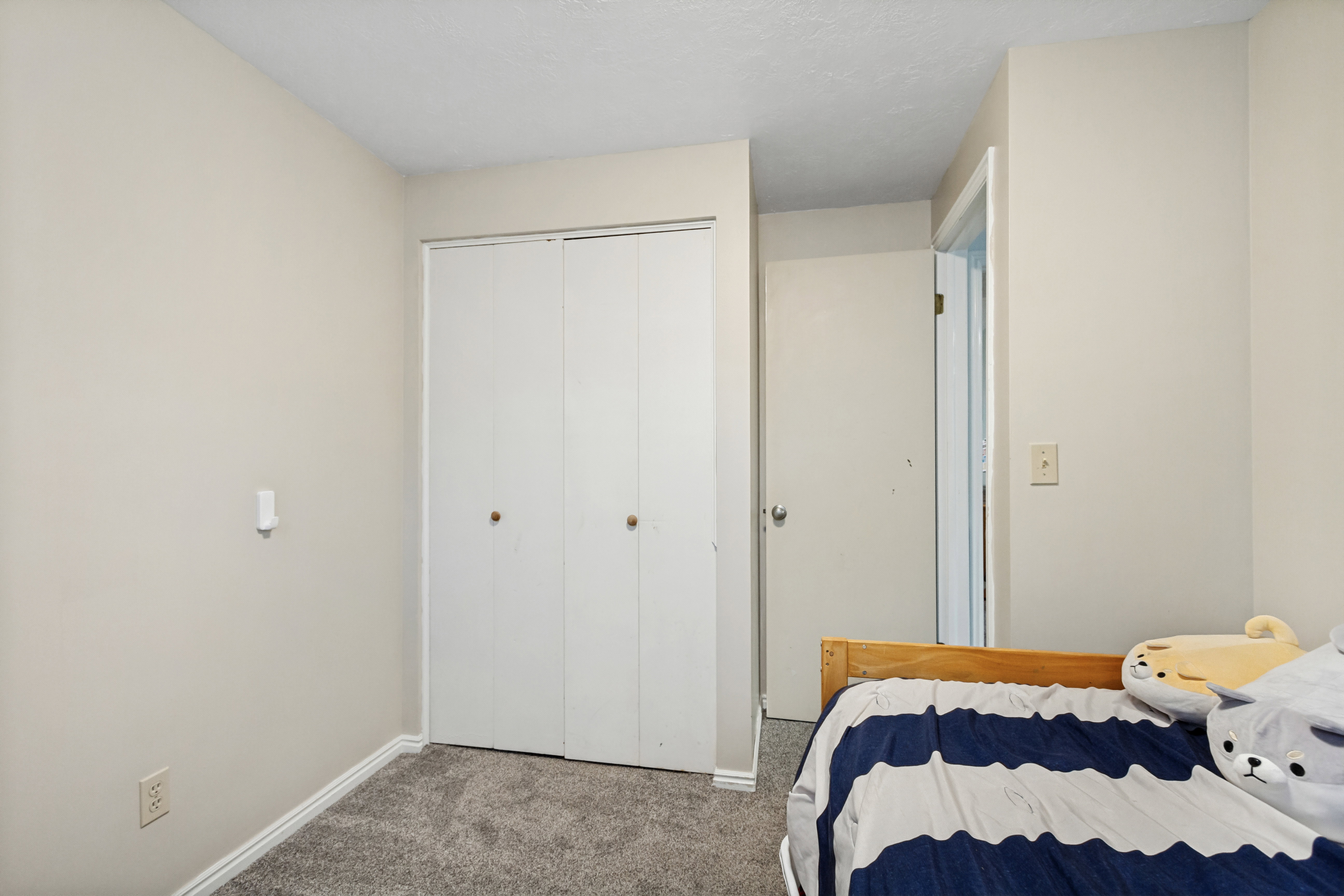 Bedroom featuring neutral wall paint, white trim, and gray carpet flooring