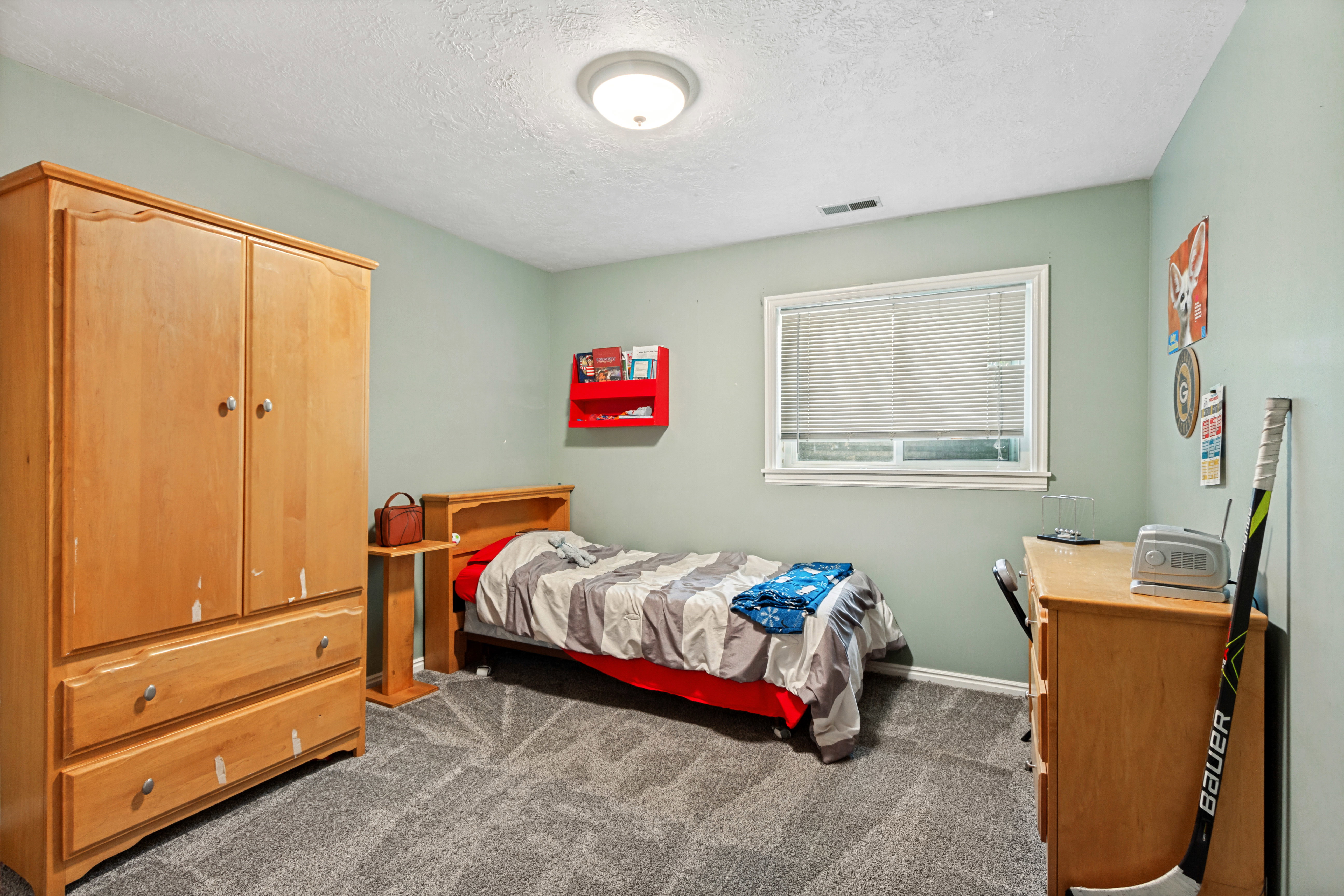 Carpeted room with a single window featuring white blinds and trim