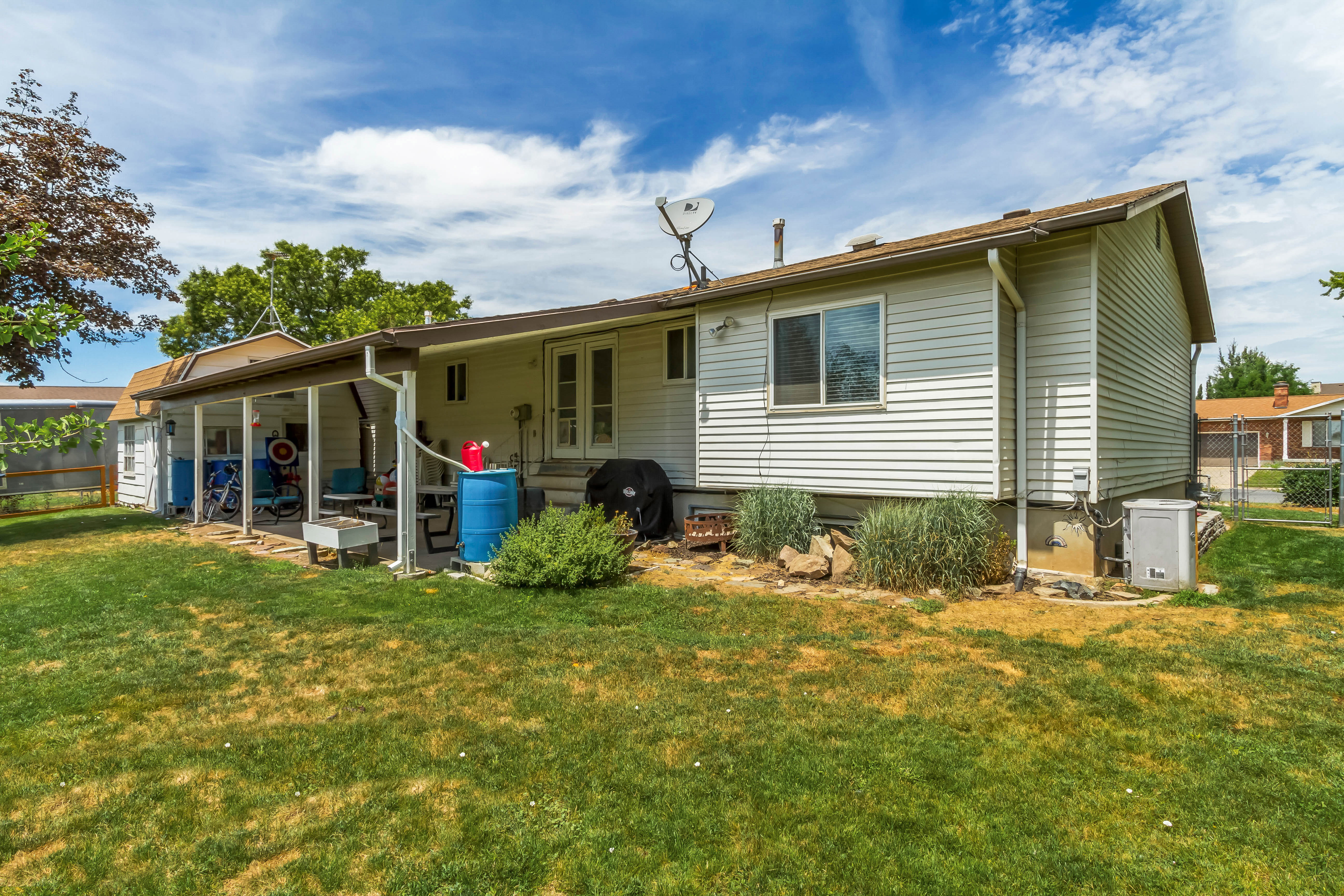 Rear exterior featuring white horizontal siding and a covered patio