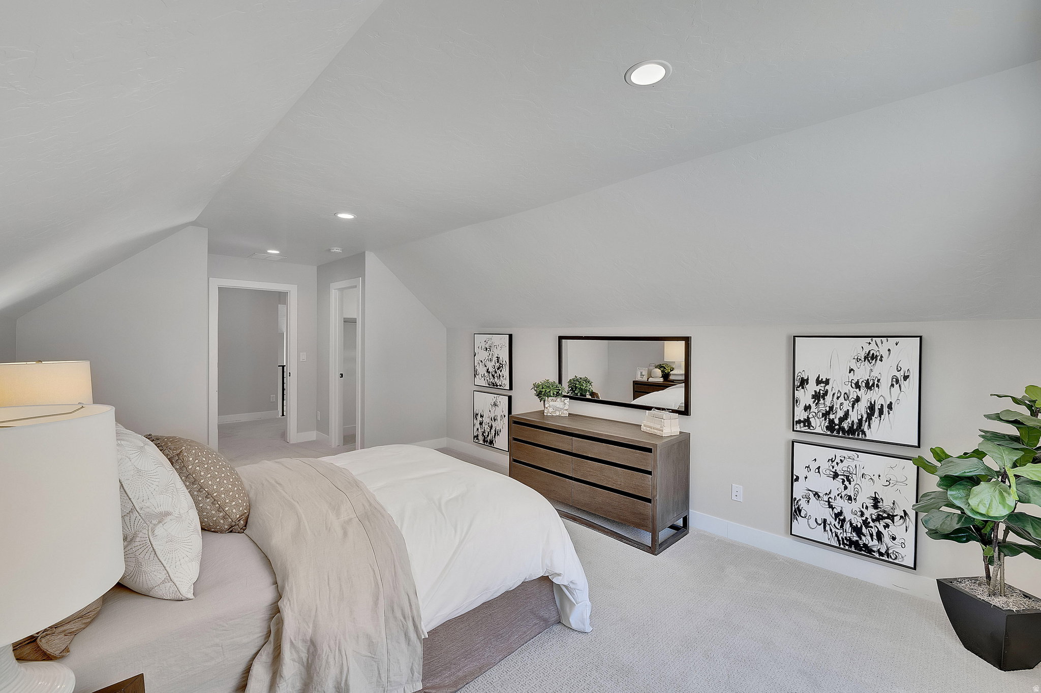 Carpeted room with sloped ceilings and recessed lighting. This is not the actual home being built but a representation of the features available in this home. Colors and finishes may differ from those shown.