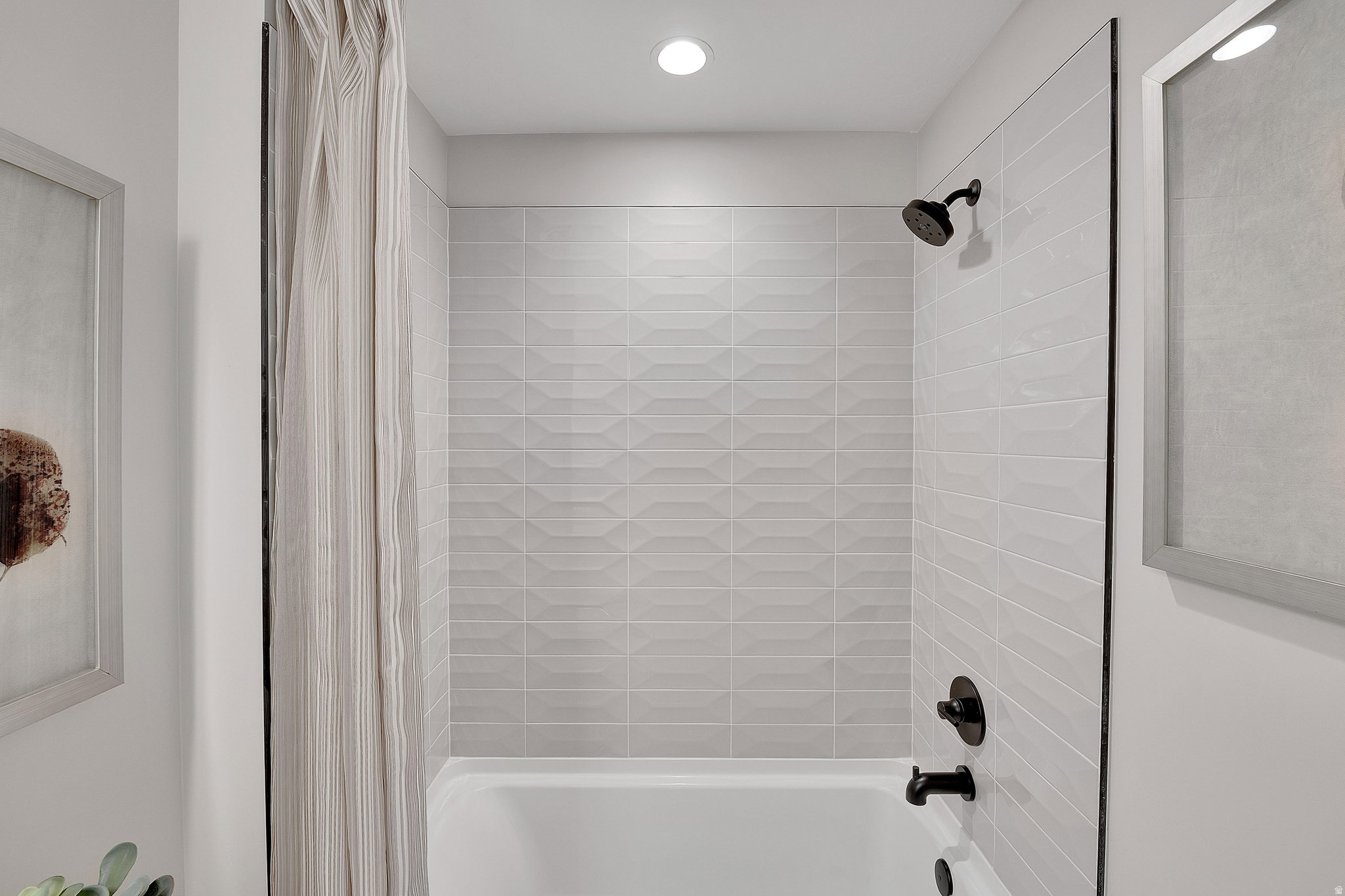 Tub and shower combination featuring black matte fixtures. This is not the actual home being built but a representation of the features available in this home. Colors and finishes may differ from those shown.